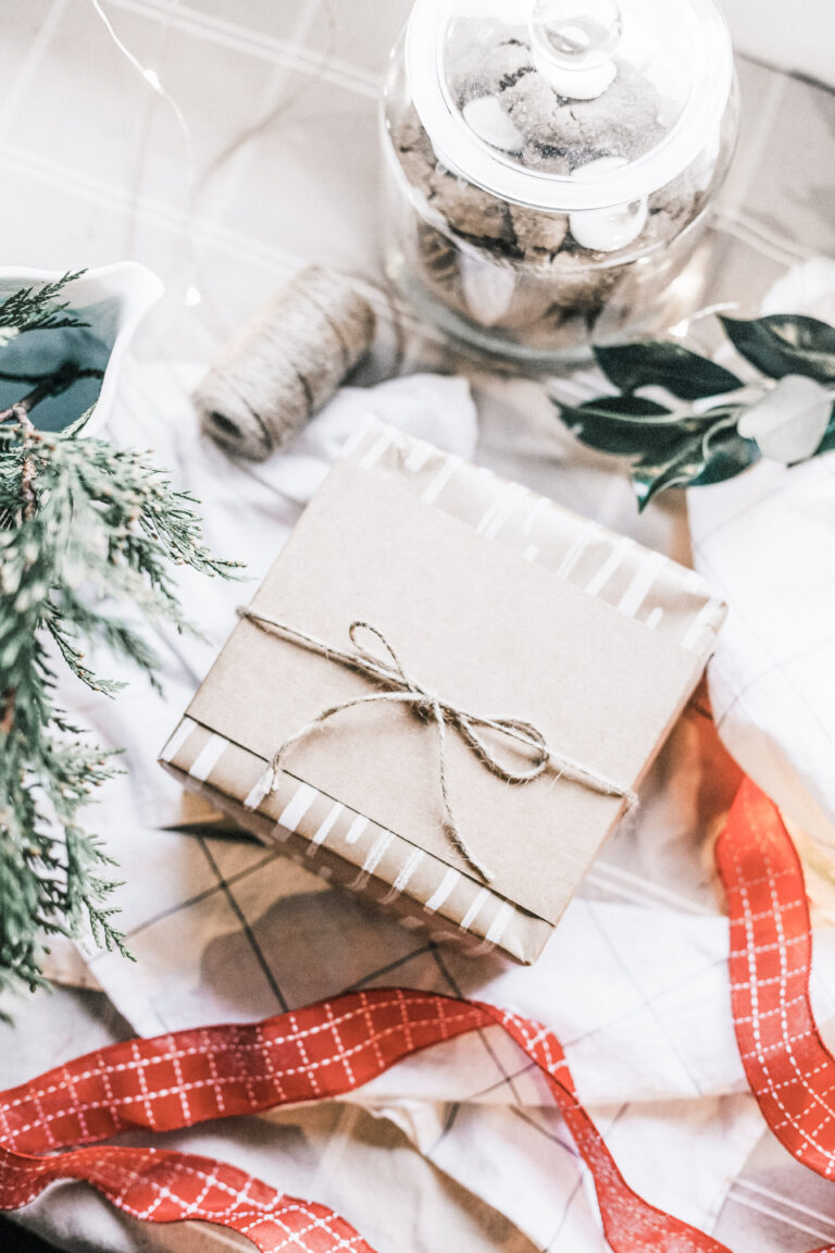A gift is wrapped with sustainable materials and surrounded by wrapping materials. This article covers the do's and don'ts when coming up with Holiday Giveaway Ideas.