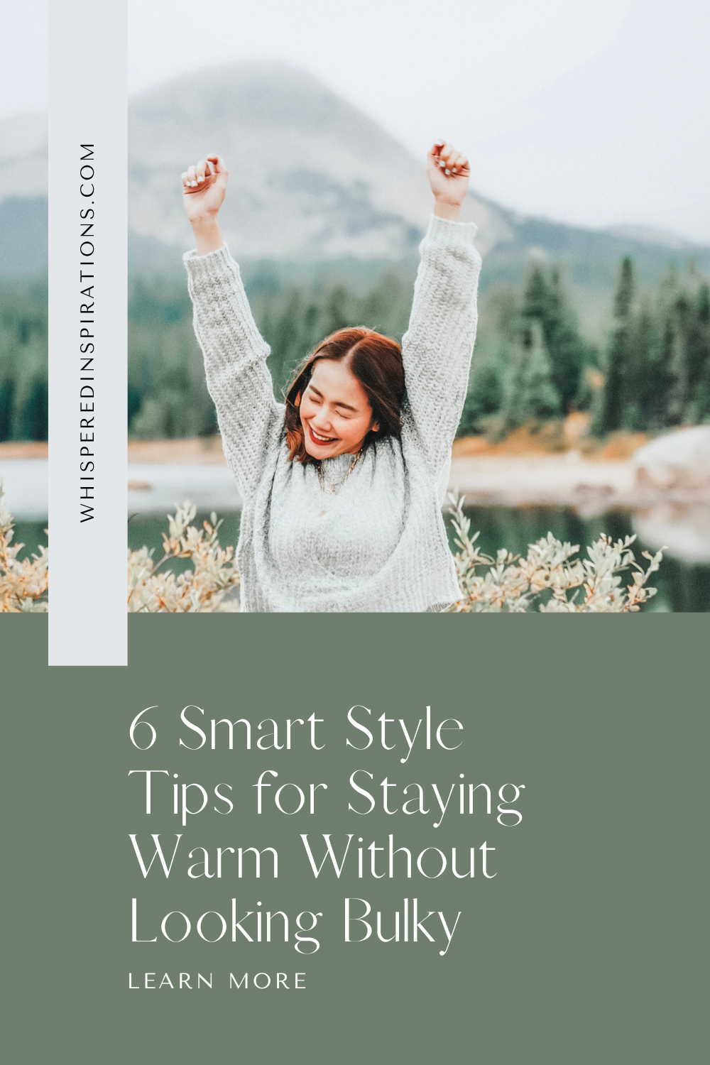 A woman throws her hands in the air, closes her eyes, and smiles. She is outside by a lake surrounded by nature. This article covers style tips for staying warm without looking bulky.