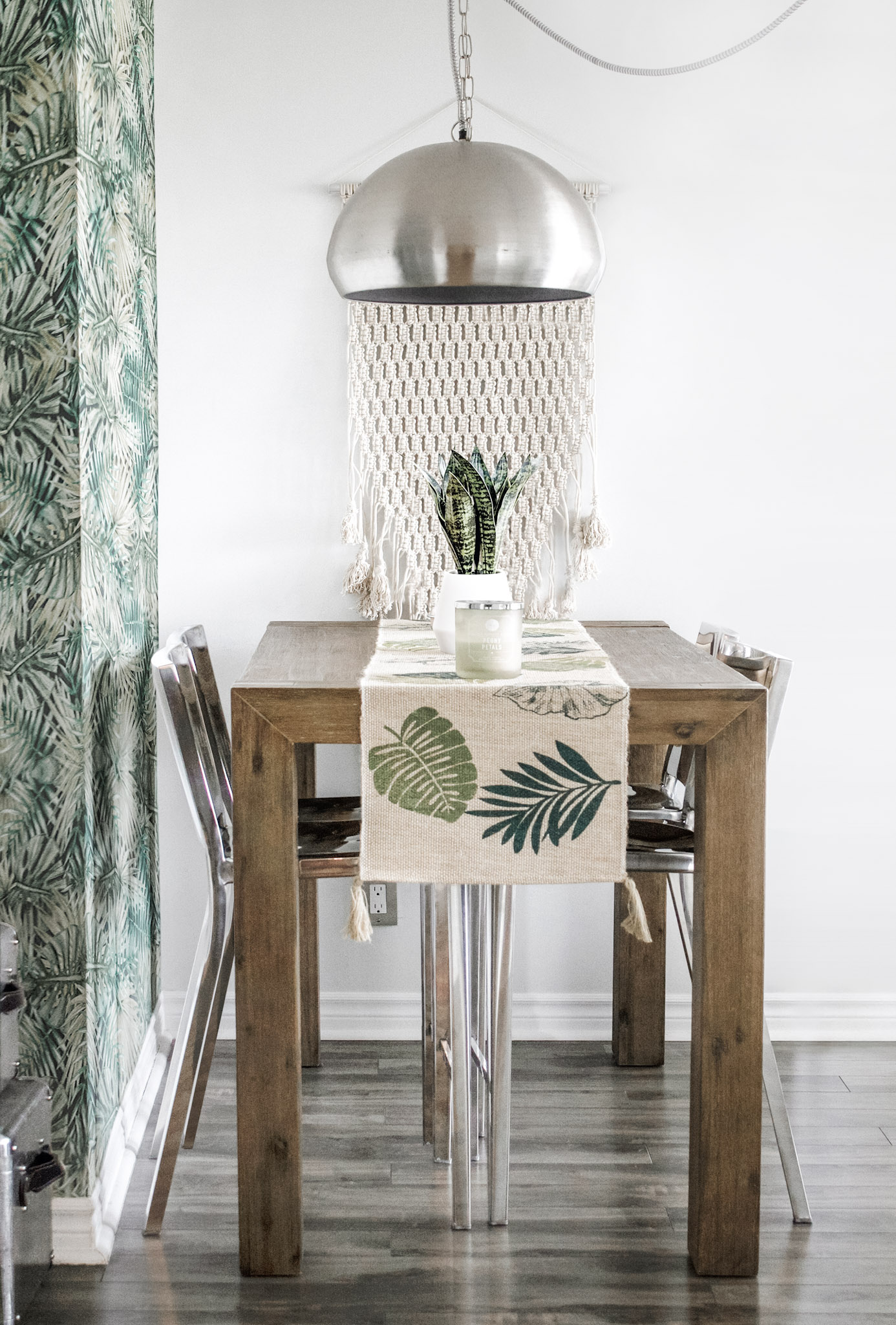 A beautiful boho kitchen with a dining room table. Has green florals and warm tones. This article covers how to get that boho style for those that love nature.