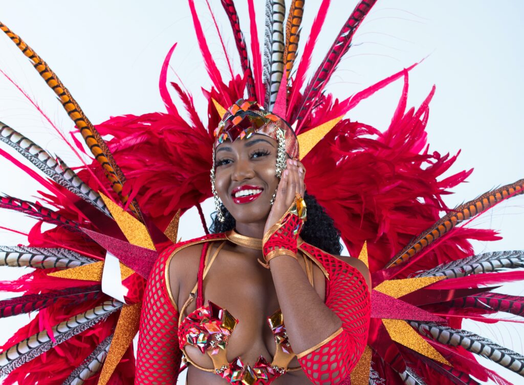A woman is dressed in Carnaval clothing with feathers and bright colors.