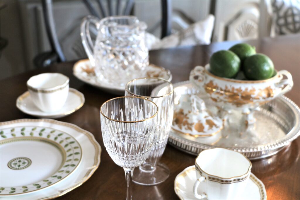 Beautiful gold and white dishes with crystal goblets. This article covers how to style photos for modern living spaces.