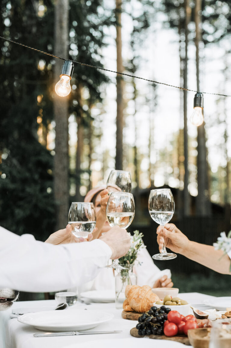 A group toast in an outdoor event setting. This article covers tips to transform your backyard into the ultimate party venue.