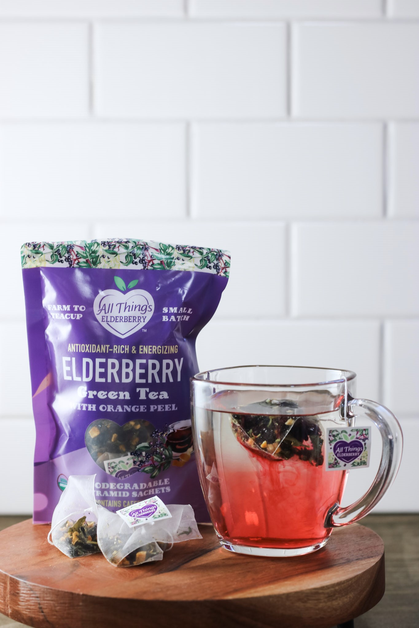 Elderberry tea teeps in a clear mug.