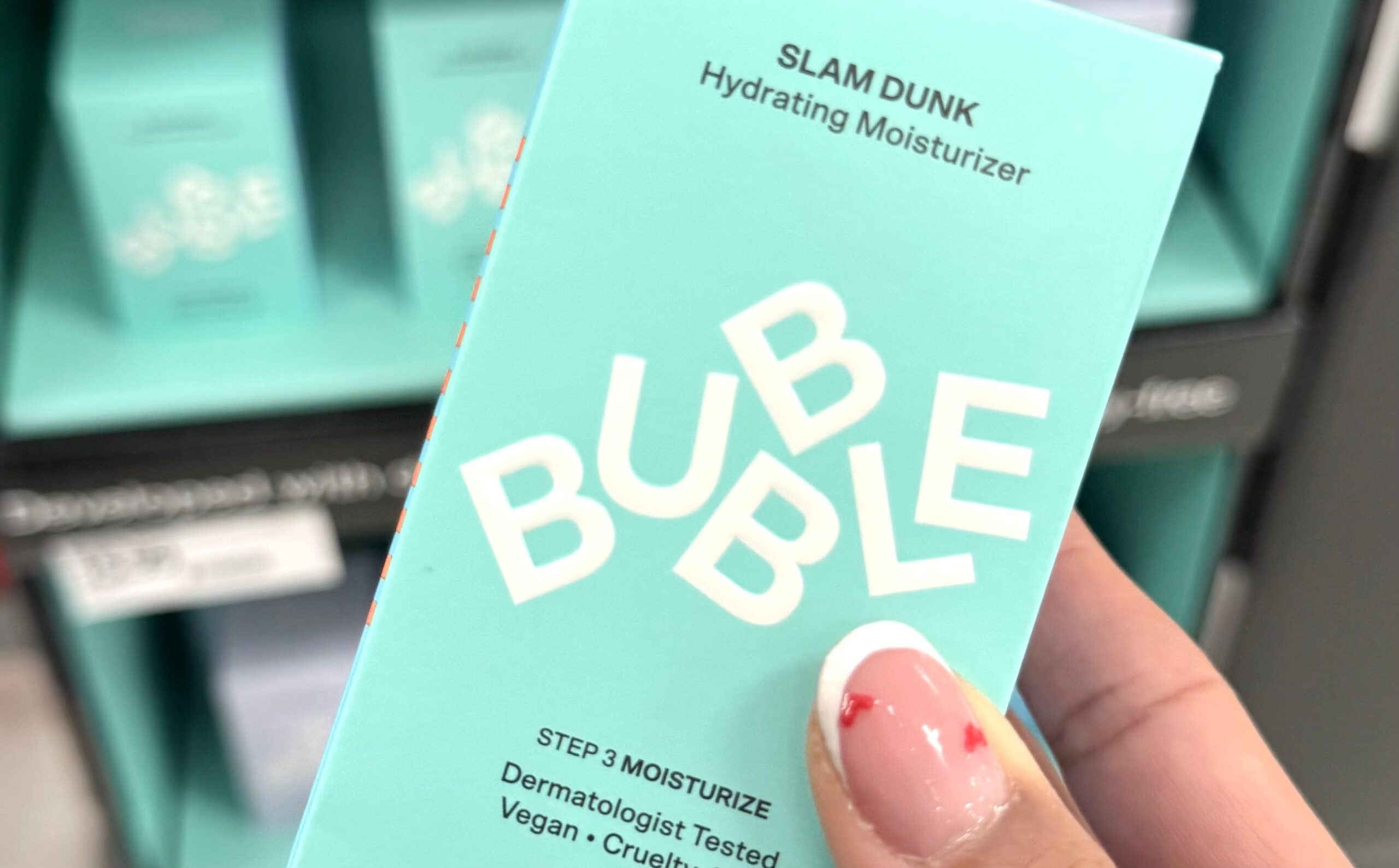 A manicured hand holds a Bubble Moisturizer at Target.