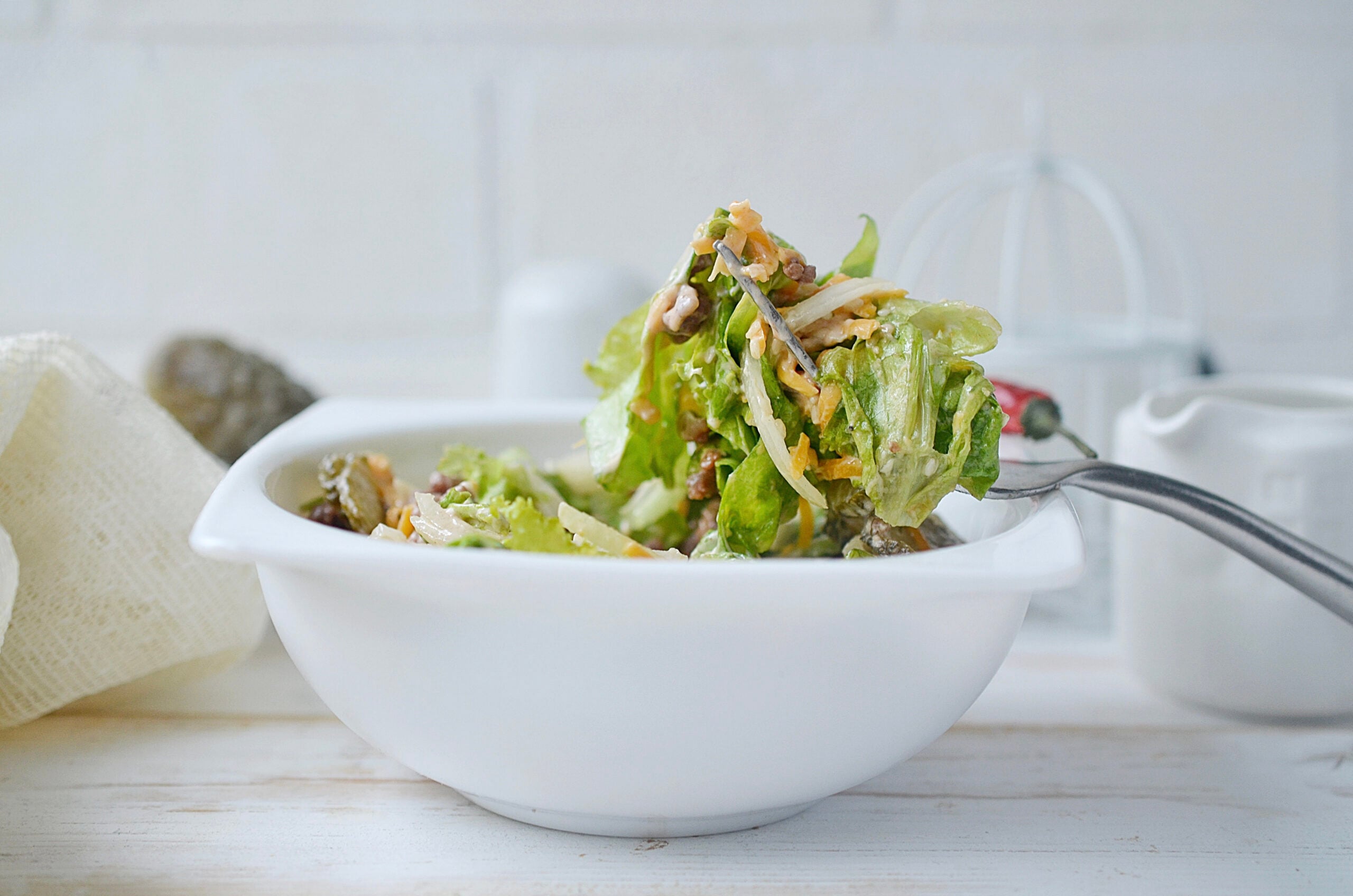 Holding up a Big Mac in a Bowl with a fork.