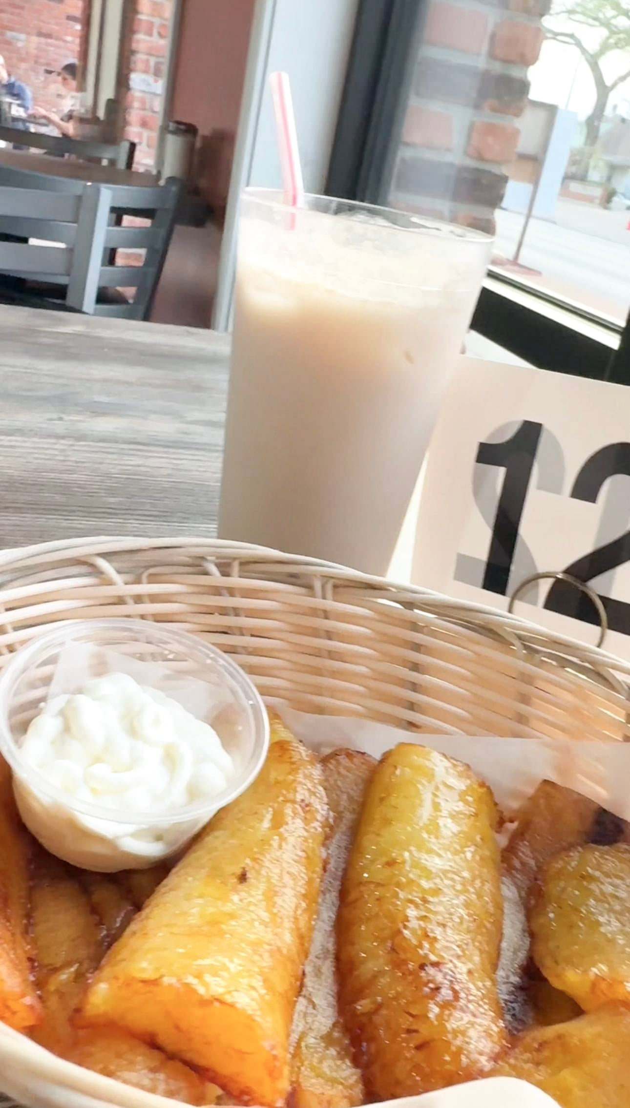 A glass of horchata with a side of platanos and crema (fried plantains and sour cream) a delicious Salvadoran side.