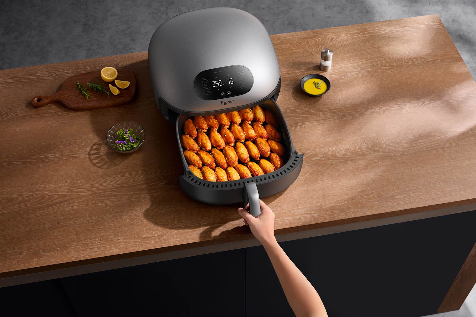 Chicken wings are being cooked in an air fryer, a person is pulling them out of the cooker. An air fryer with hamburger patties is shown. There are buns and cheese on the side. This article shares how to make the perfect air fryer hamburger.