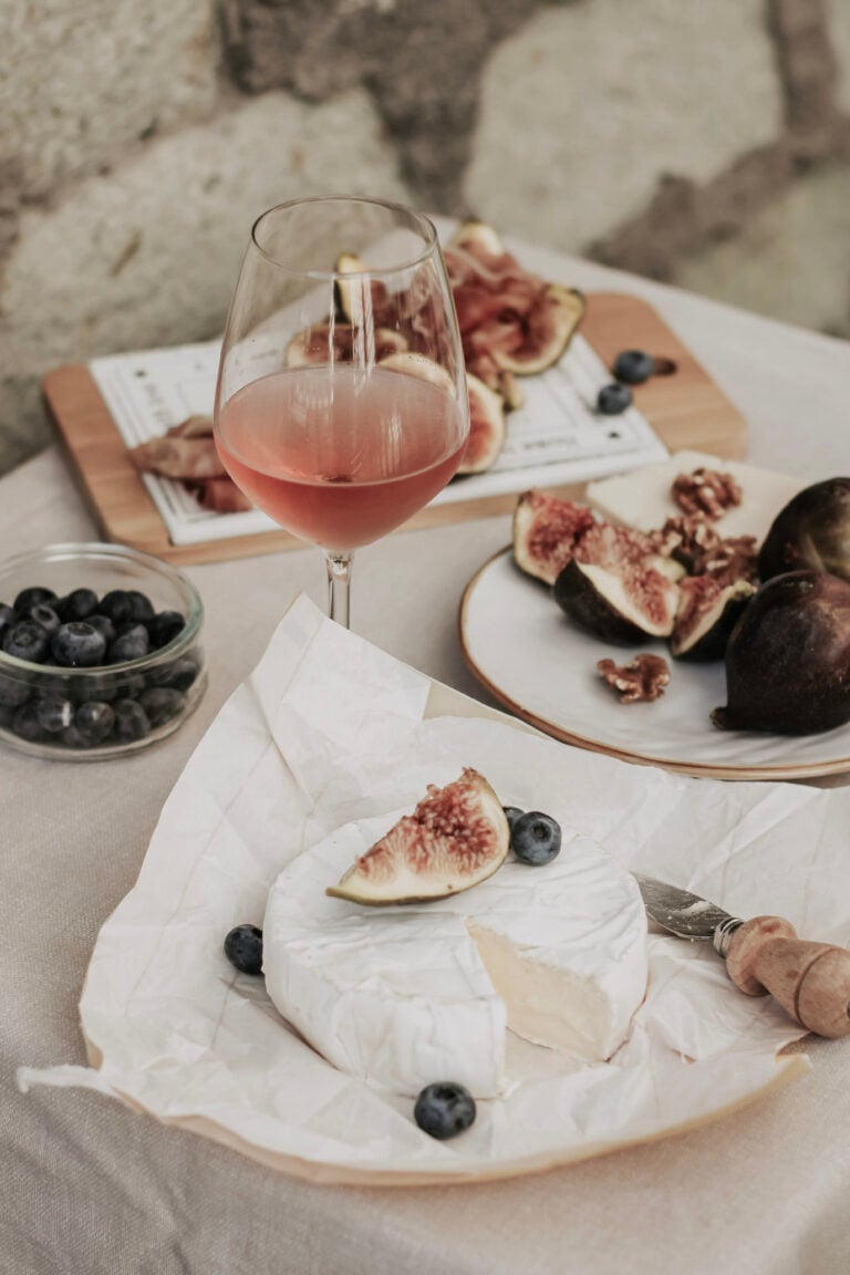 Wine is shown with various fruits and cheeses. This article covers a beginner's guide to wine tasting.