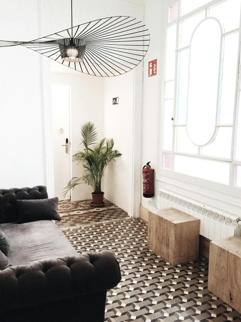 A minimal and modern living room is shown with a unique pendant light. This article covers stylish and functional home upgrades.