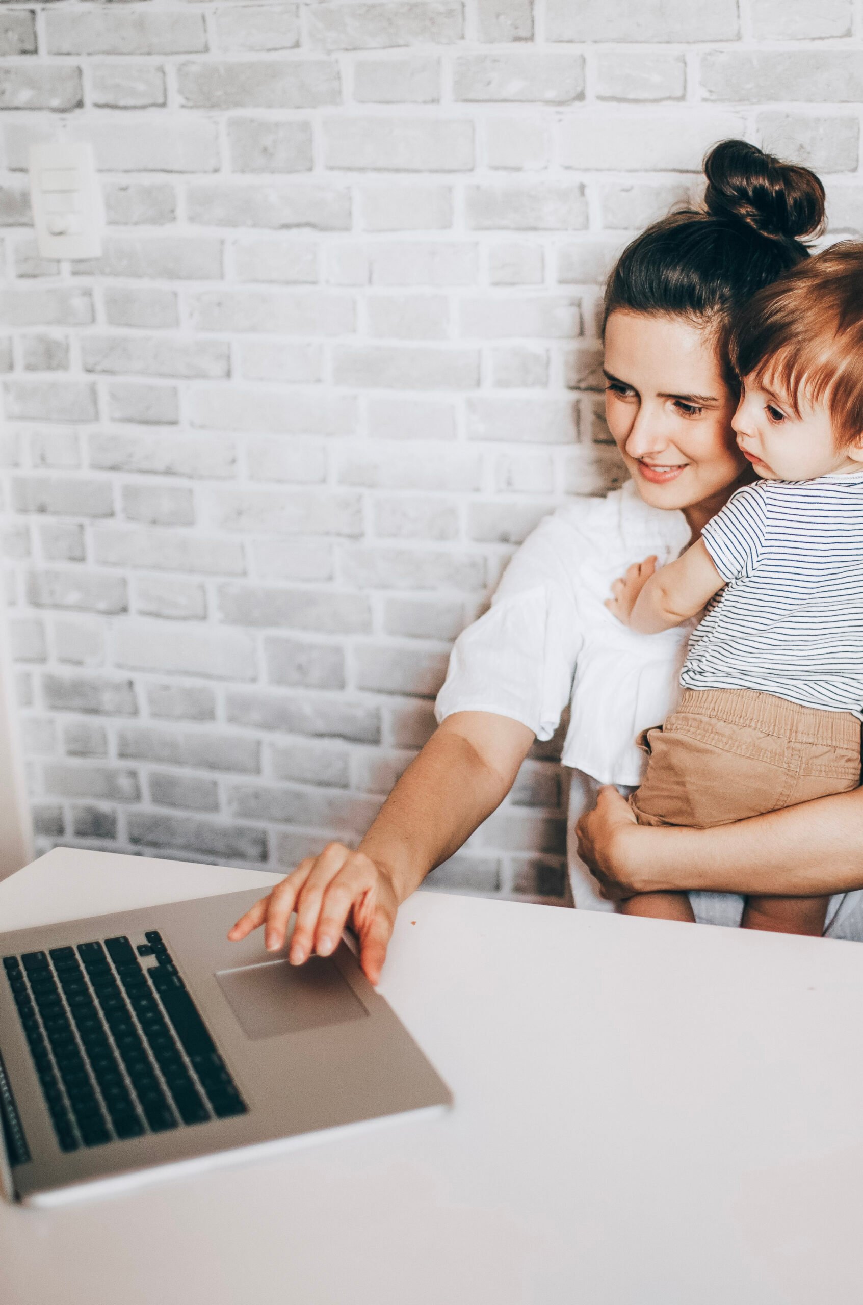 Woman holds child in her lap and works on a computer. This article covers how to start and RESP.