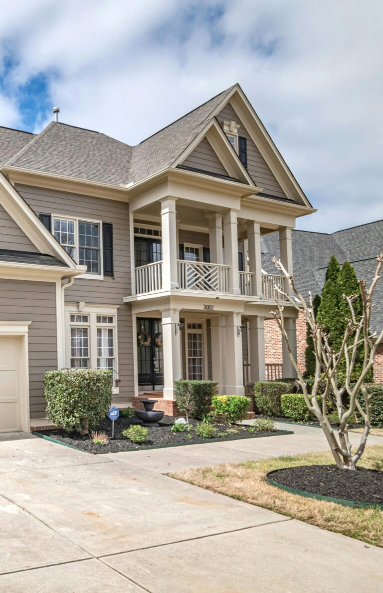 A beautiful gray suburban home with ornate windows. This article covers how custom window shapes add personality to a home.