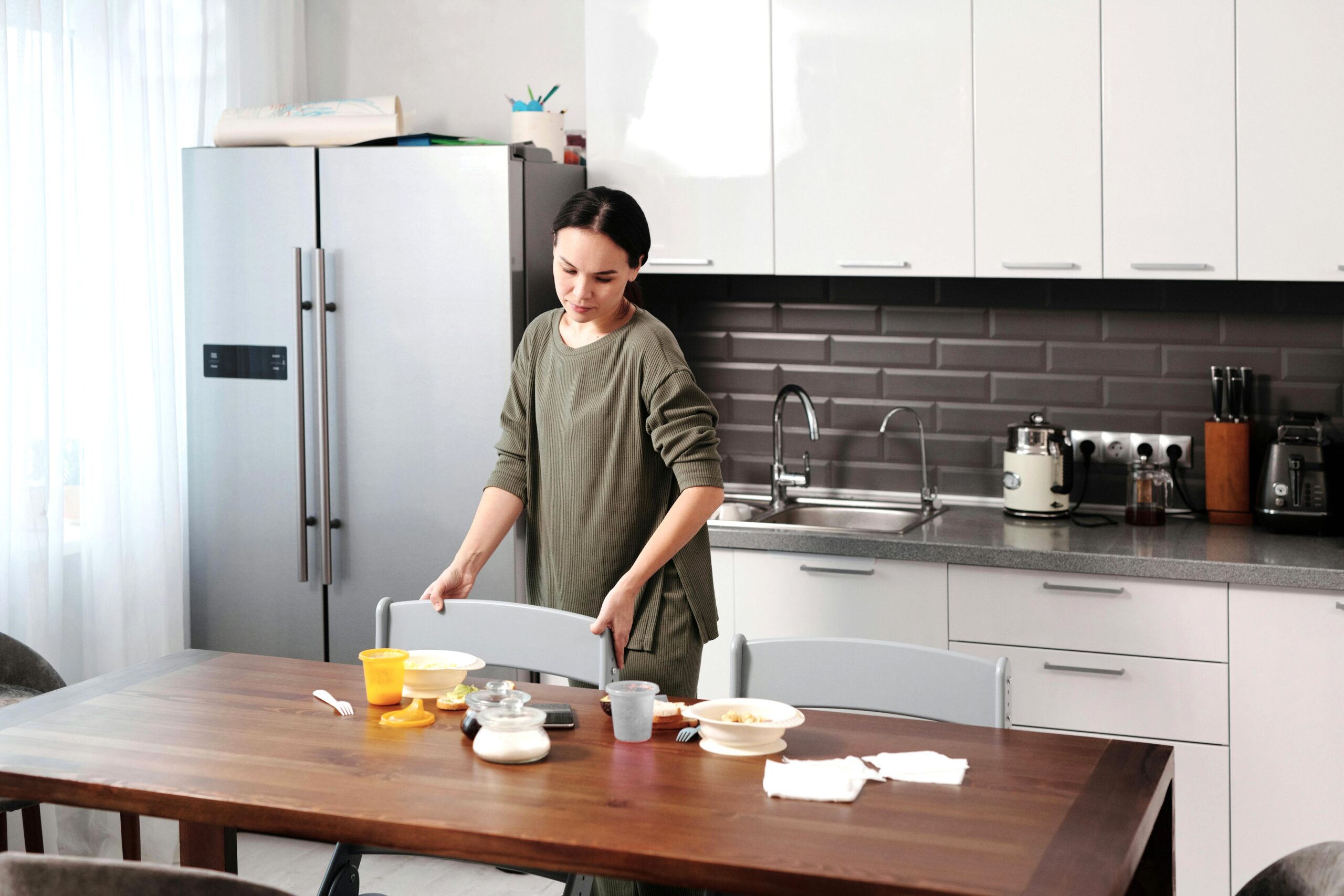 A woman sits down at a table with a healthy meal in front of her. This article covers why being happy and healthy should be your goals.