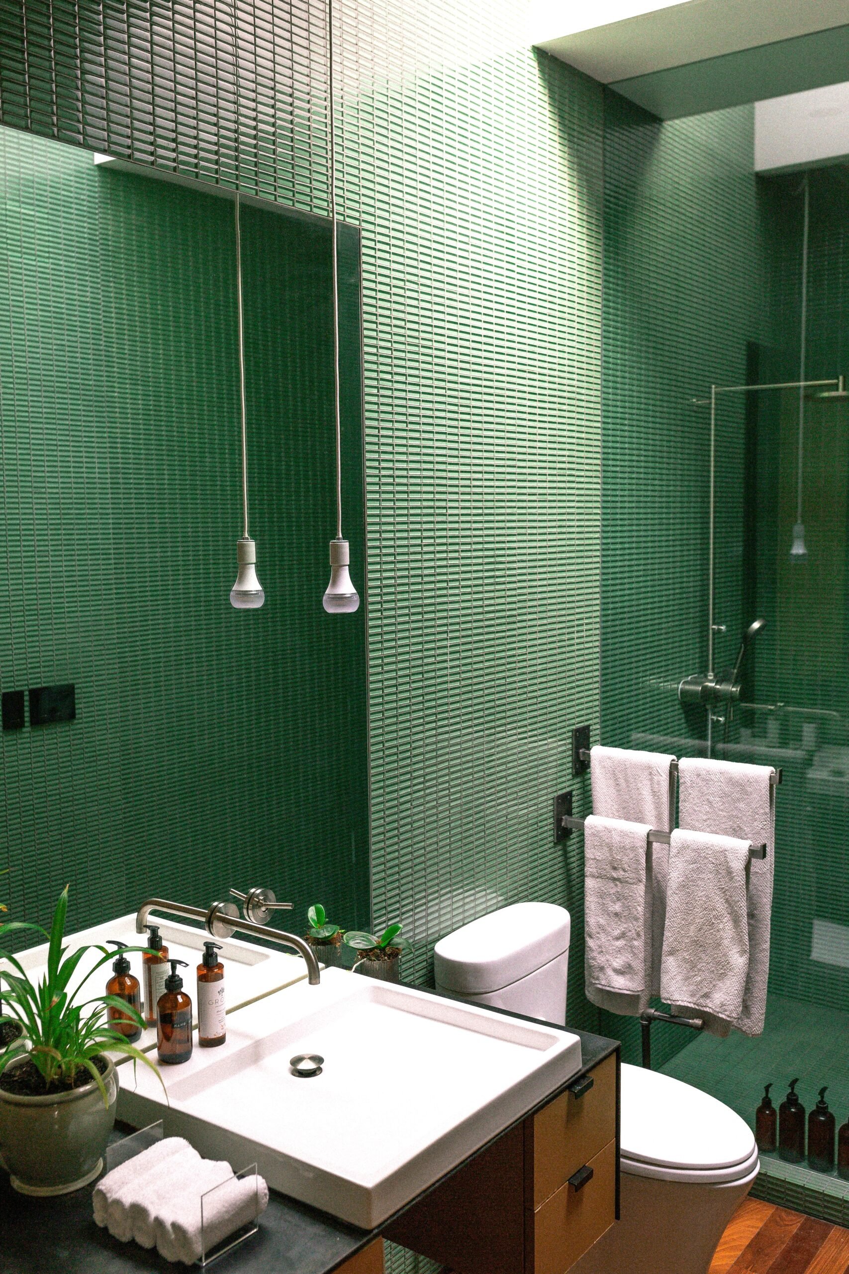A beautiful, modern, minimal, green tiled bathroom is shown. This article covers creative kitchen and bathroom remodel ideas for modern homes.