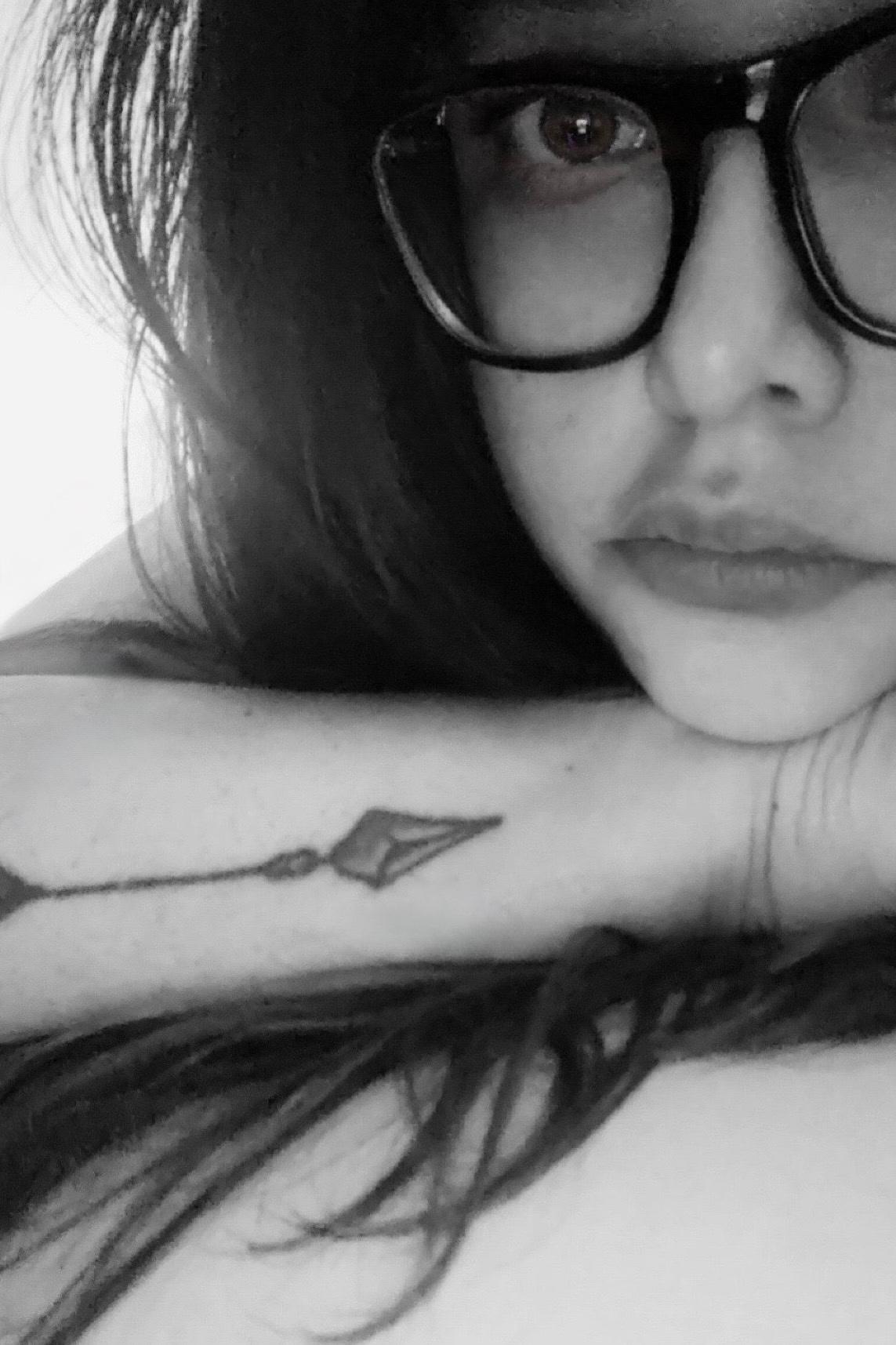 Nancy resting her chin on her arm, partial part of her face visible. Black and white portrait.