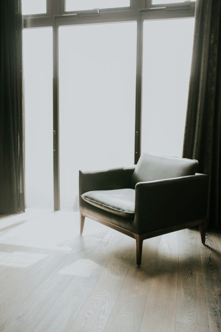 A mid-century modern style chair sits next to a window near a window with bright sun. This article covers how to protect your furniture from the sun.
