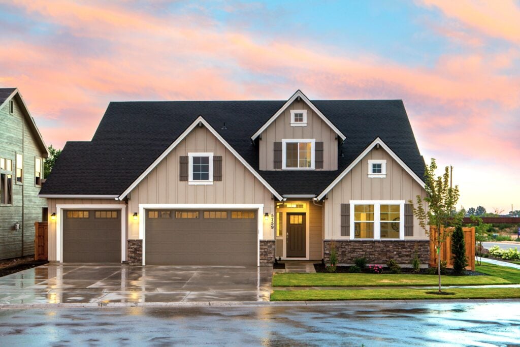 A house with a beautiful sunset behind it, shows a large garage. This article covers how to make your garage feel brand new.