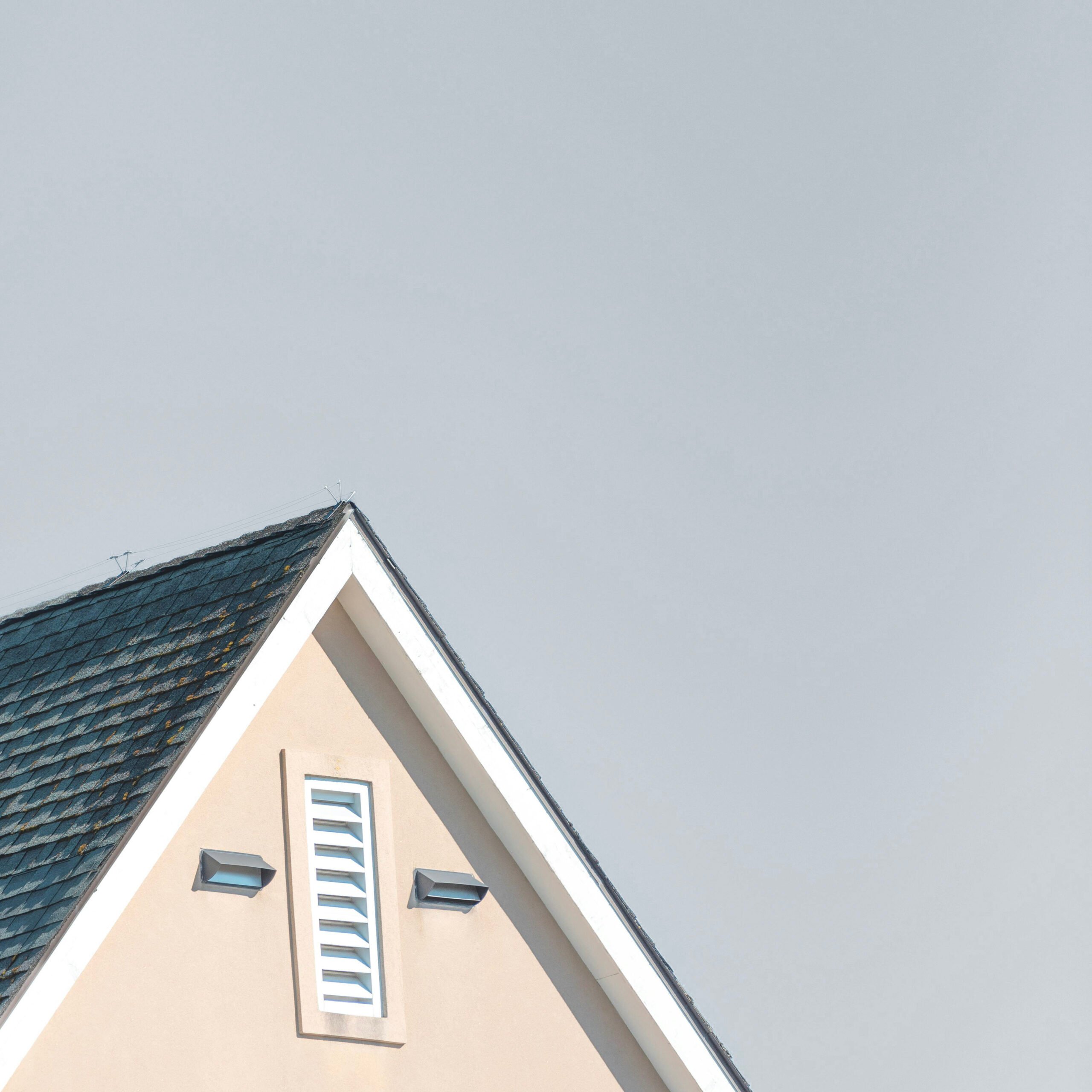 A roof of a home is pictured against a sky. This article answers the question, is your roof quietly warning you it's time for a change?