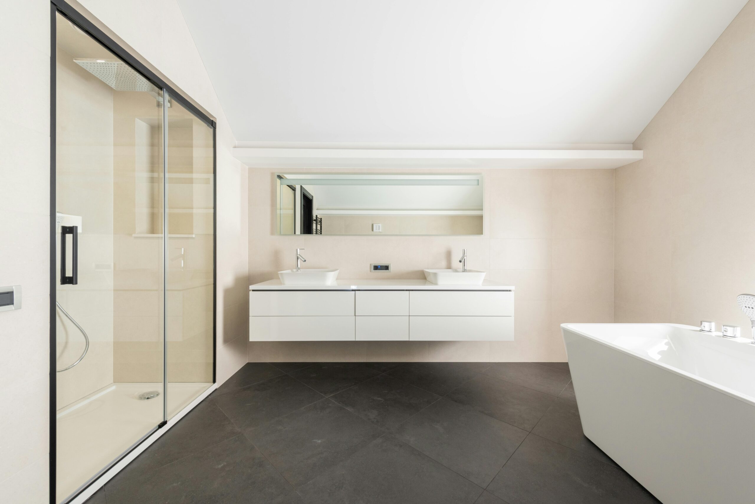 Super modern bathroom in white and beige. Floating cabinet, modern tub and shower. This article covers comfort as a priority. Rethinking how homes serve modern families.