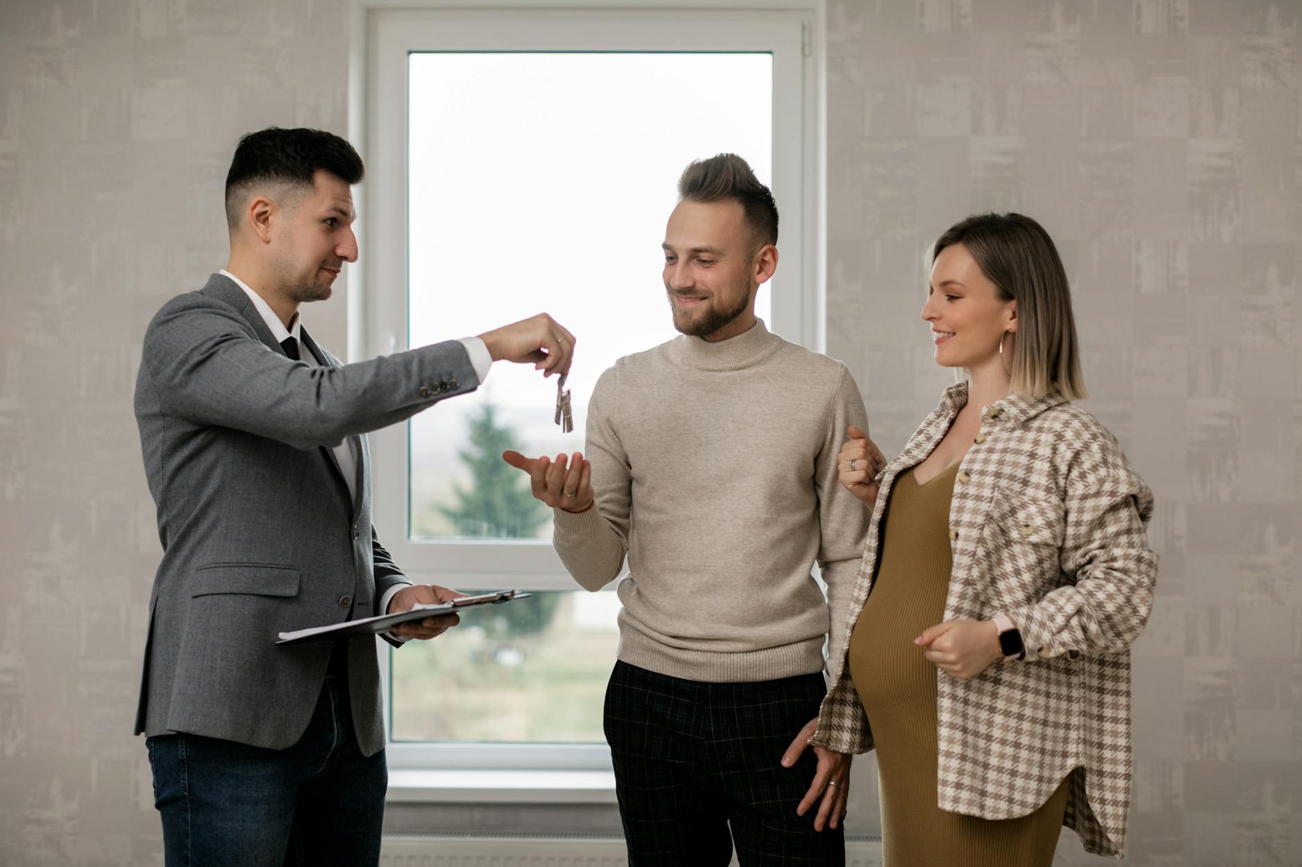 A real estate agent handing the key to the new homeowners. This article what every homebuyer should know about real estate attorneys.