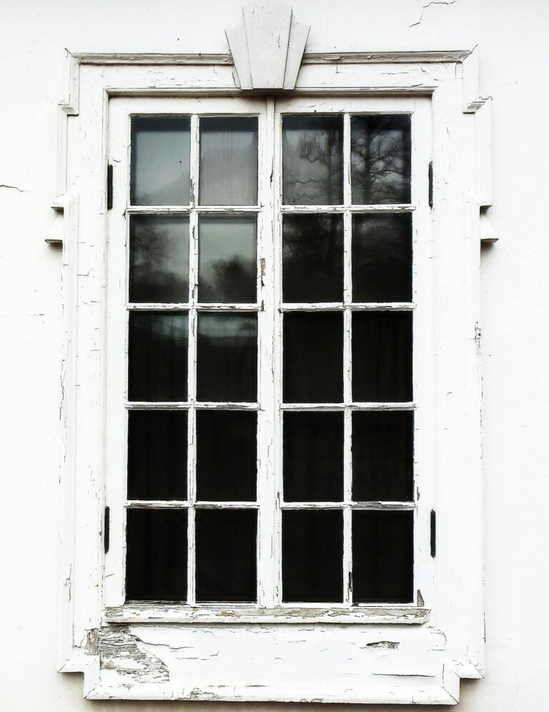 A white, old, weathered window is shown. While it stands the test of time, this article covers 5 signs it's time to replace your old windows.
