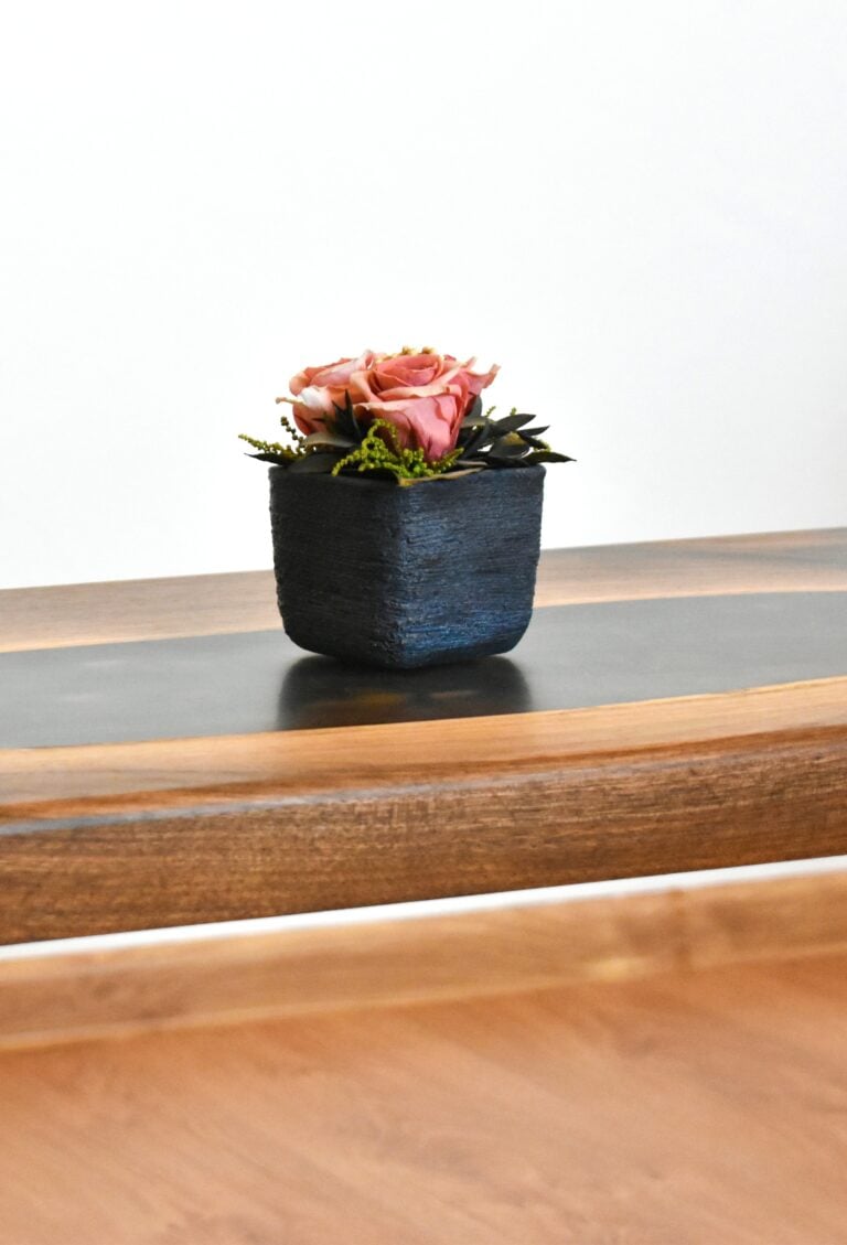 A flower sits on an epoxy table. This article covers 5 ways an epoxy table can transform your space.
