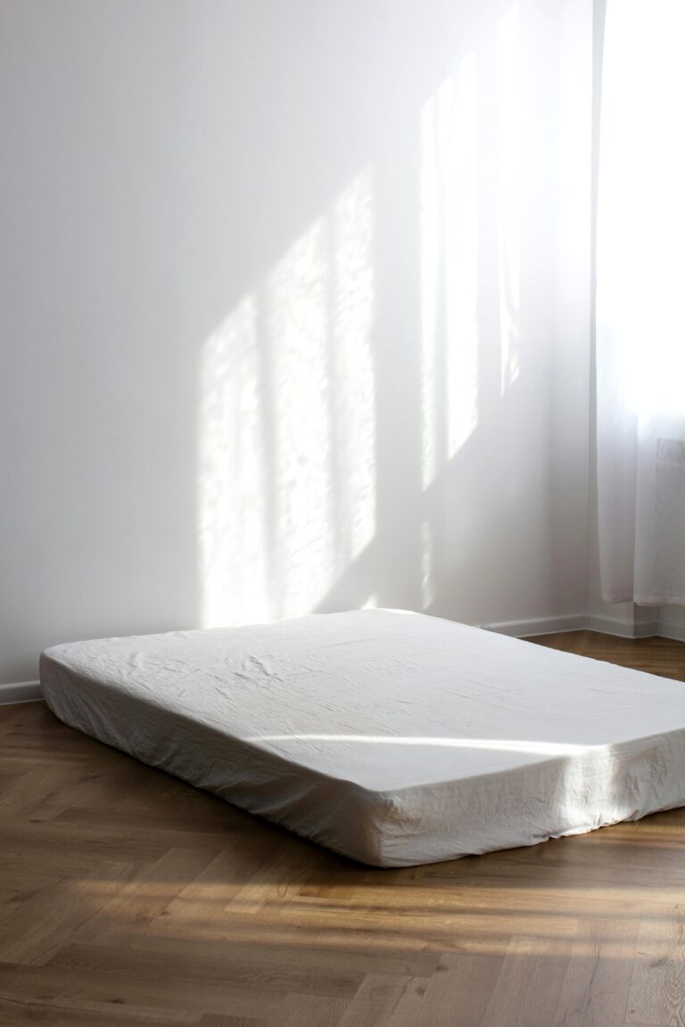 A picture of a mattress on a floor. The sun is shining on it artistically. This article covers the top 7 mattress retailers in the US for 2026.