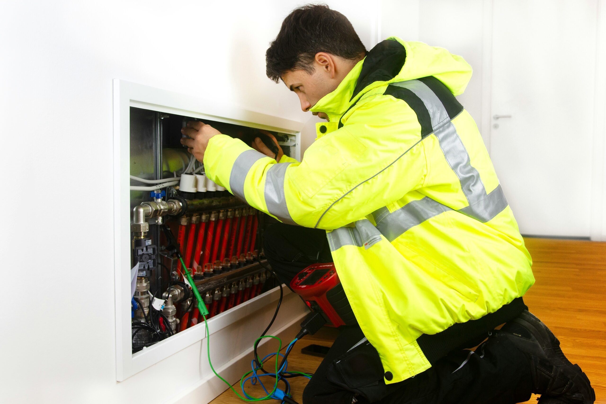 A man in a yellow jacket working on a system. This article provides the homeowner's guide to extending the life of expensive systems. 