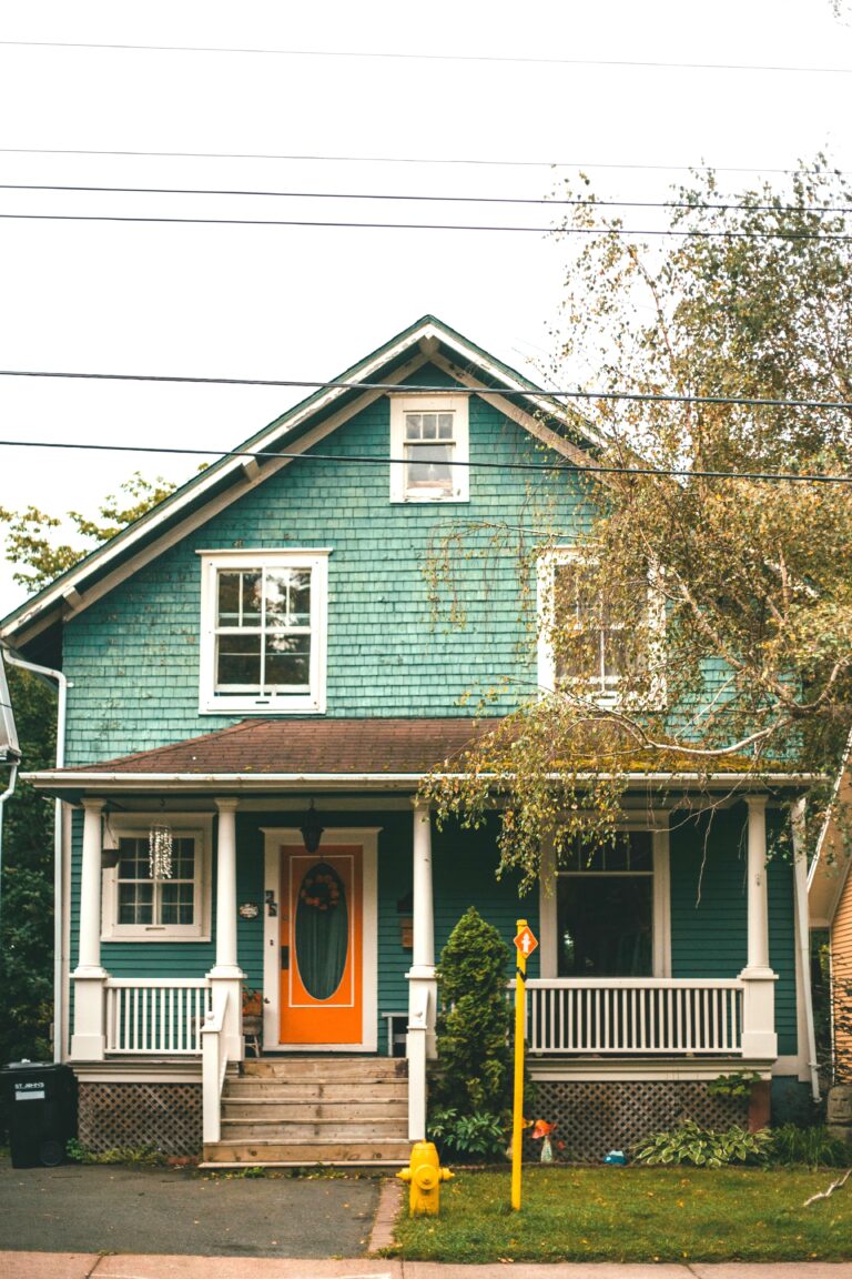 A beautiful, modest, green home is shown on a street. This article covers why selling a house as-is is a smart financial decision for homeowners.