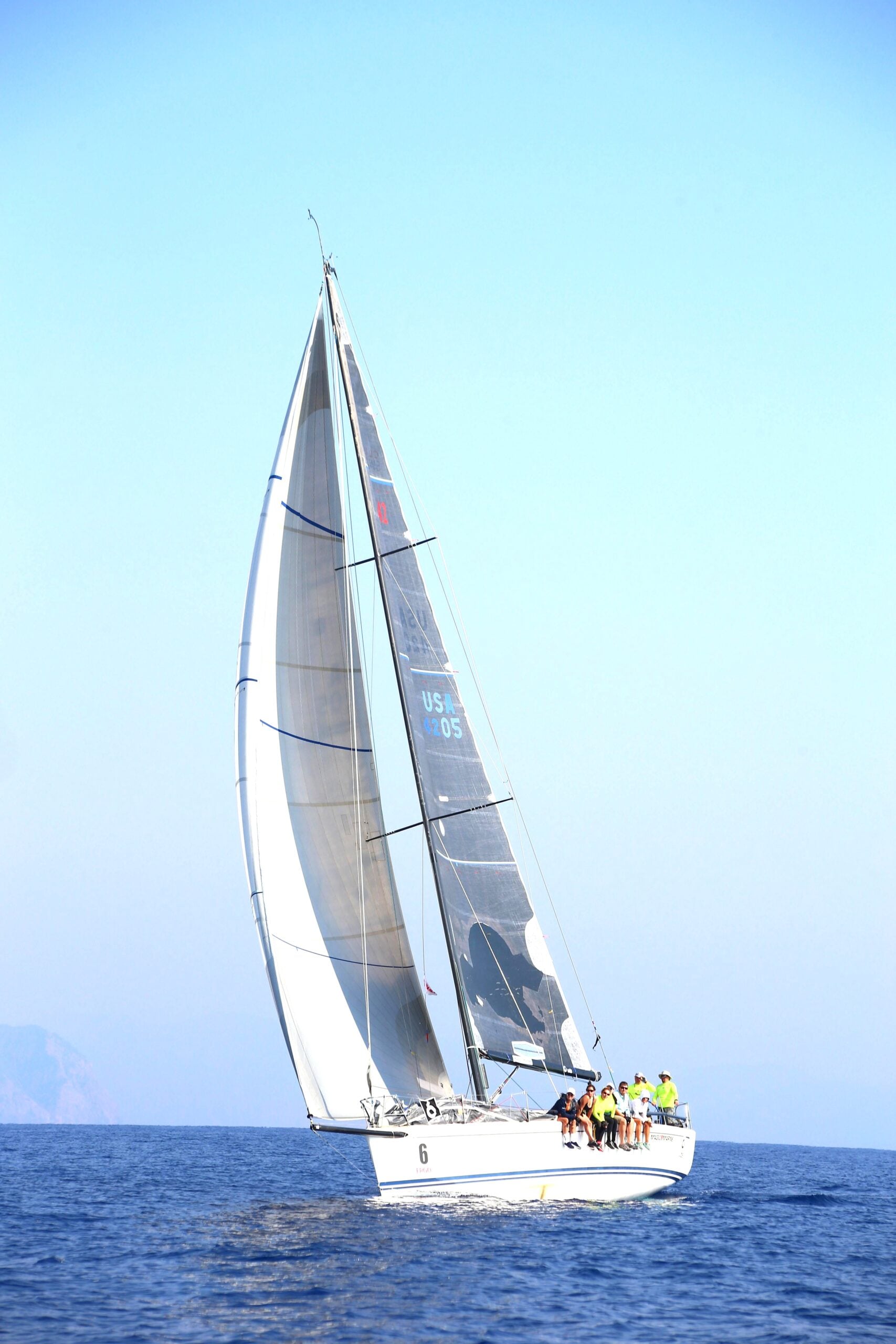 A sail boat with a group of people onboard. This article covers what to expect from a learn-to-sail vacation. A first-timer's guide.