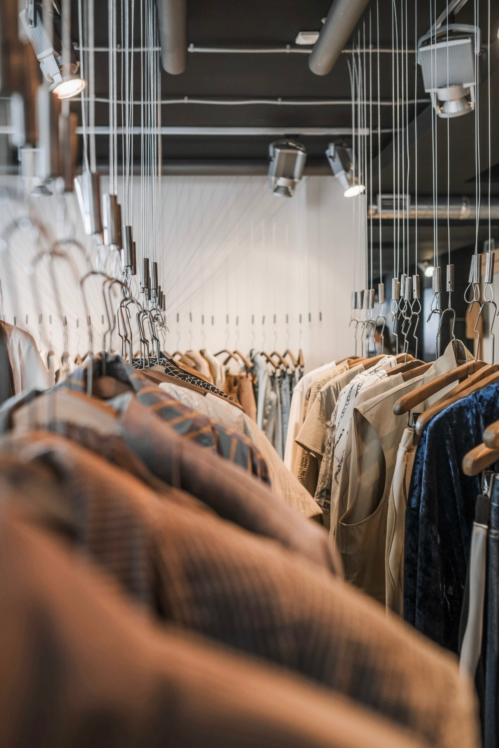 Vertical shot of fashionable clothes on hangers in a stylish boutique setting. This article covers what today's fashion-conscious shoppers really look for in a boutique.