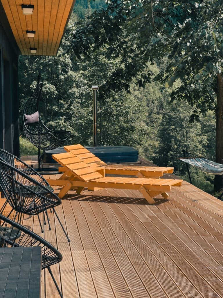A modern deck with bright orange deck furniture. This article covers modern deck design trends.