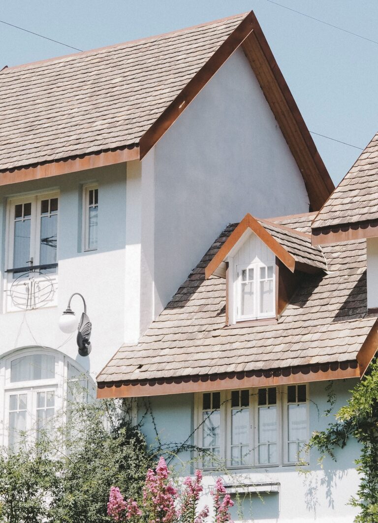 A beautiful white home with light shingles. This article covers how CertainTeed shingles make a difference in your home's curb appeal.