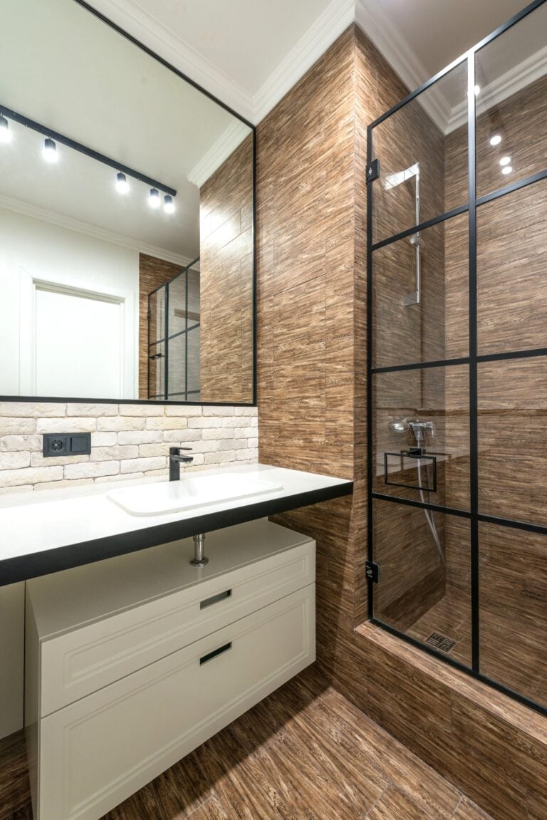 A beautiful black, white, and natural modern bathroom is shown. This article covers smart shower upgrades that make daily life easier.