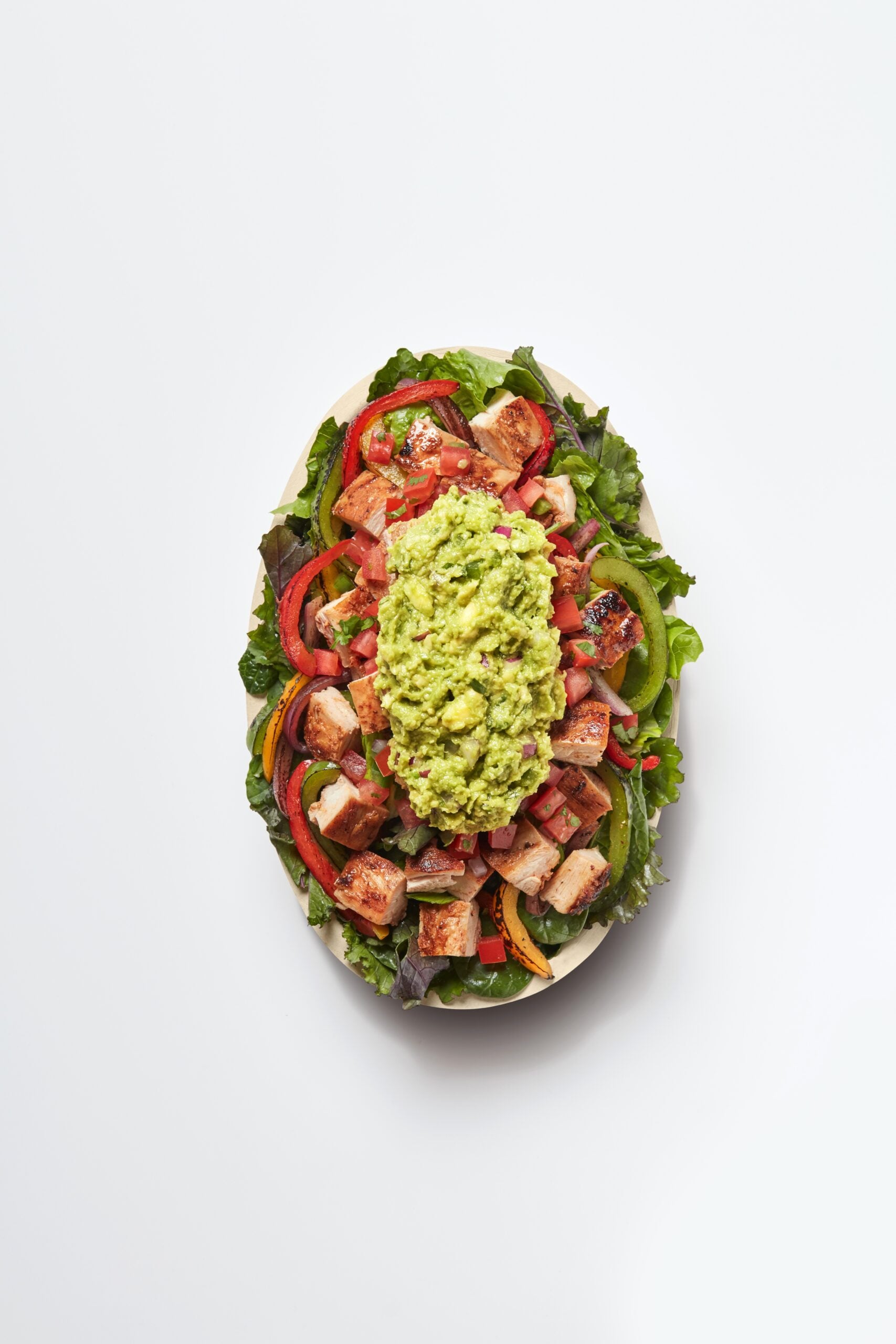 The top view of a super greens chicken bowl with avocado from Chipotle. This article shows you how to eat Chipotle and still lose weight.