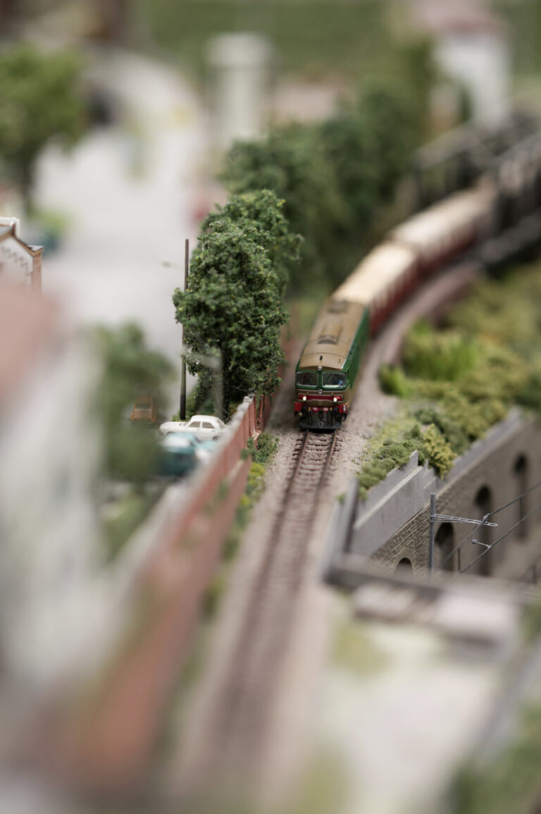 A close up of a miniature train and track within a miniature landscape. This article shares how to start a miniature building hobby with your kids this weekend.