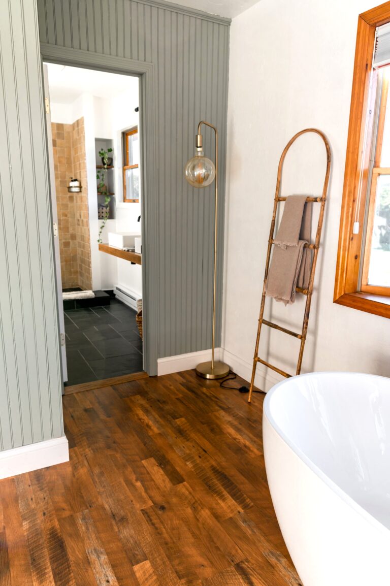 Elegant bathroom featuring a modern bathtub, wooden flooring, and minimalist design. This article shares modern bathroom remodeling trends.