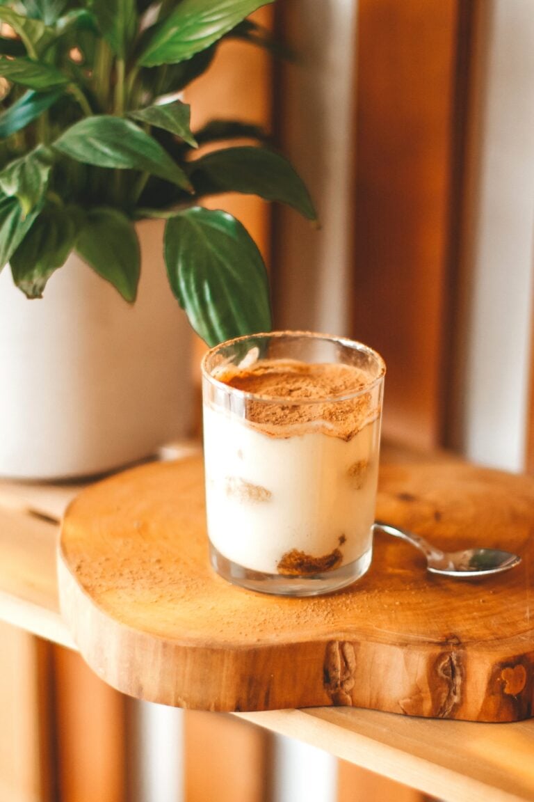 Creamy tiramisu yogurt in a glass cup on wooden board with a plant nearby. This article shares creative and practical uses for shot glasses around the home.