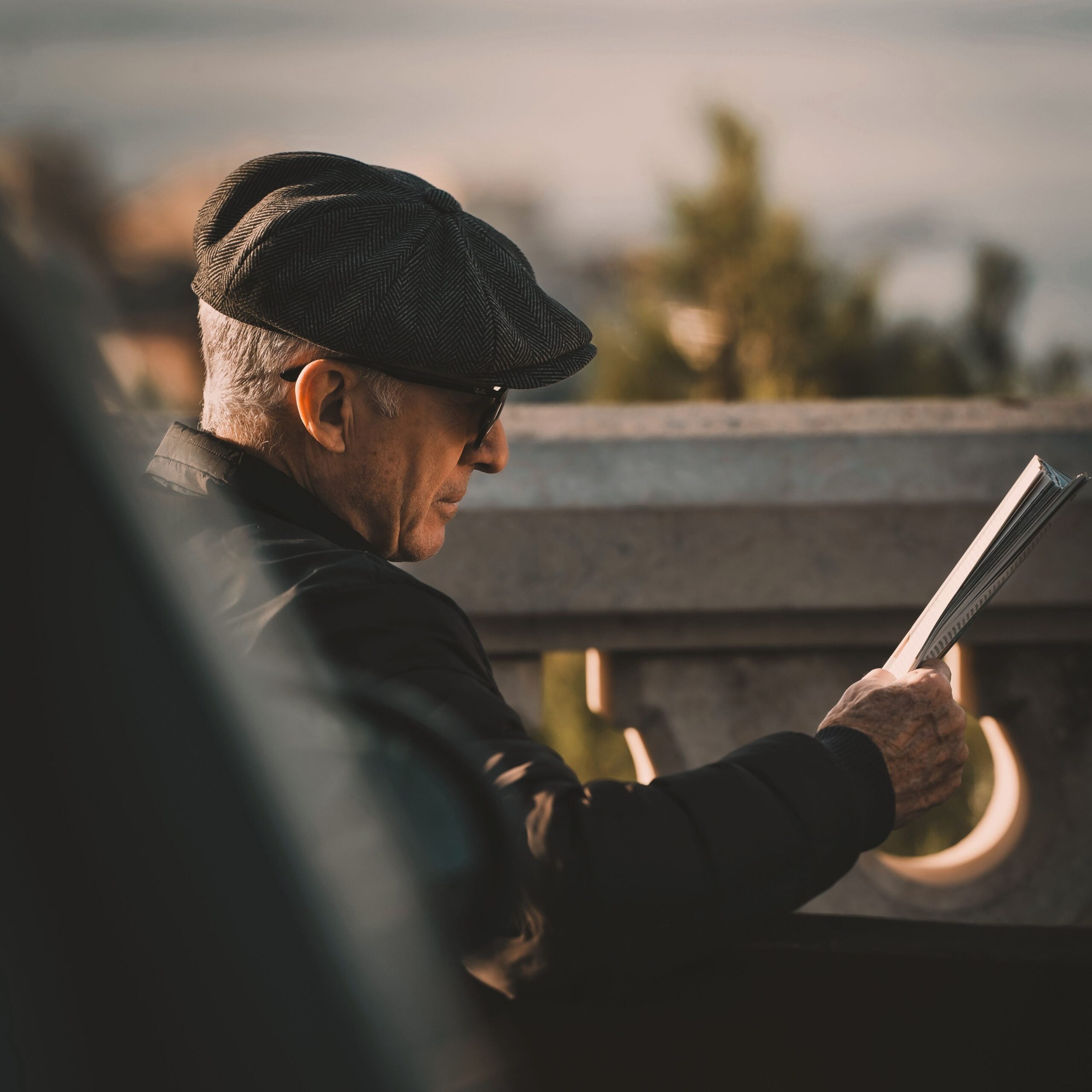 Arthur Vance, reads a file on a bright patio.
