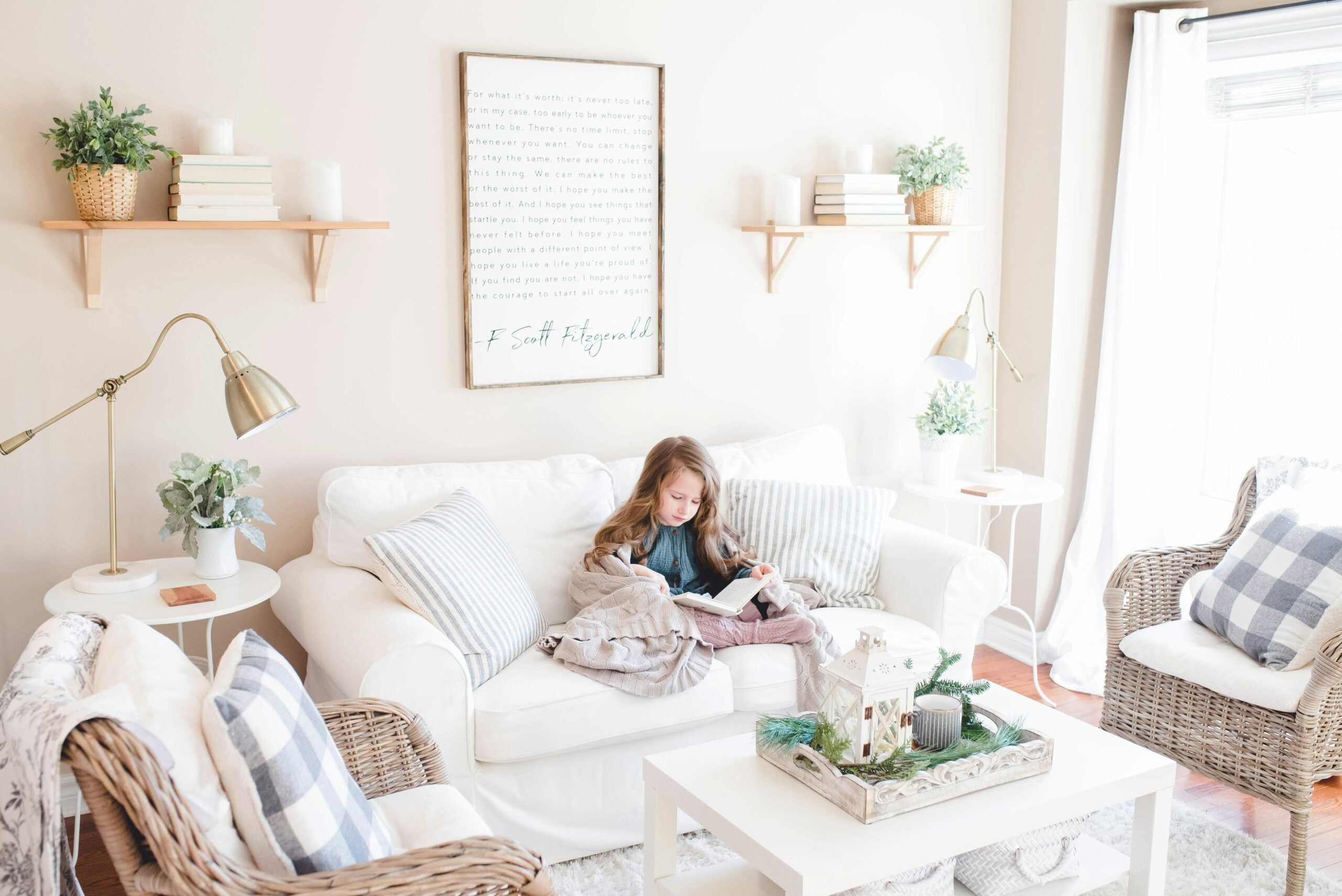 A little girl sits and reads on a couch in a bright living room. This article shares how to refresh your space with easy updates for a new look.