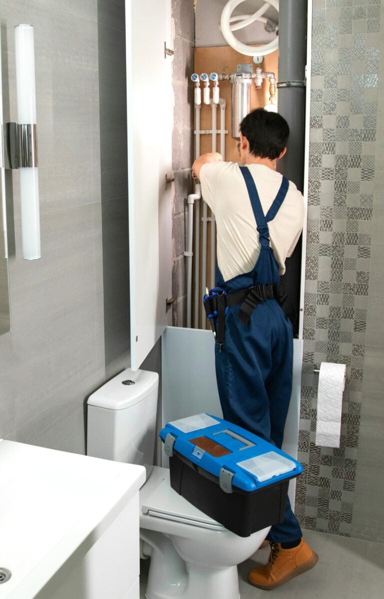 A plumber works on piping in a modern bathroom This article shares everything you need to know before hiring a plumber.