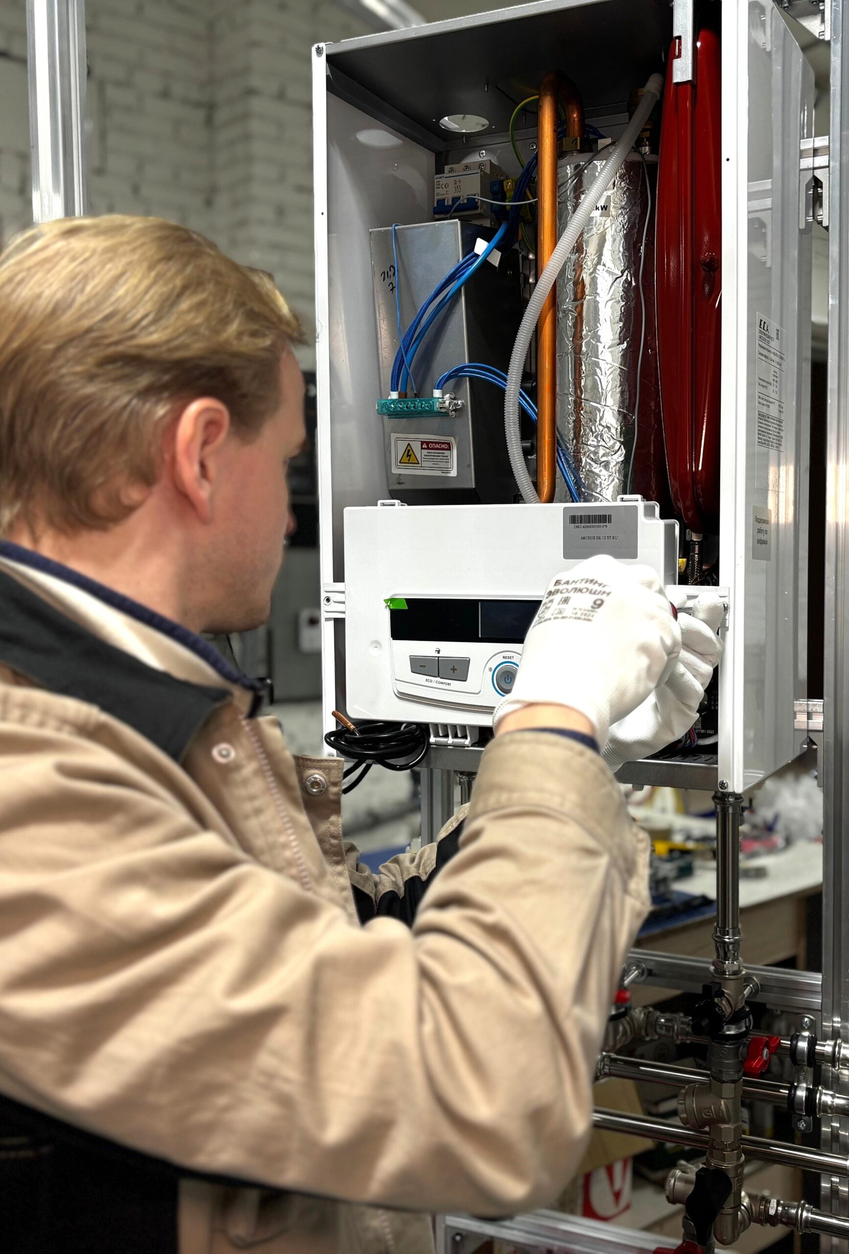 Technician installing or repairing a heating system in an indoor workshop setting. This article shares how to know when your water heater needs attention.