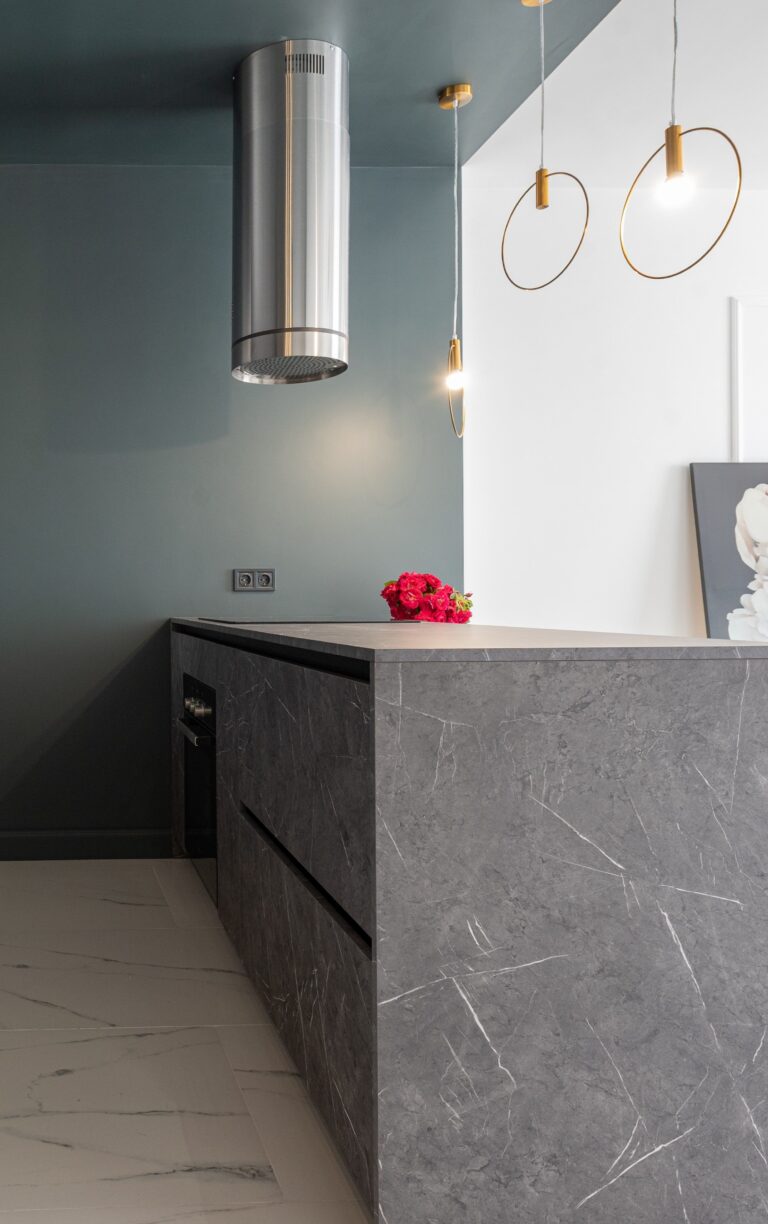 Contemporary gray kitchen with marble countertops and stylish lighting. This article helps you choose a marble benchtop.