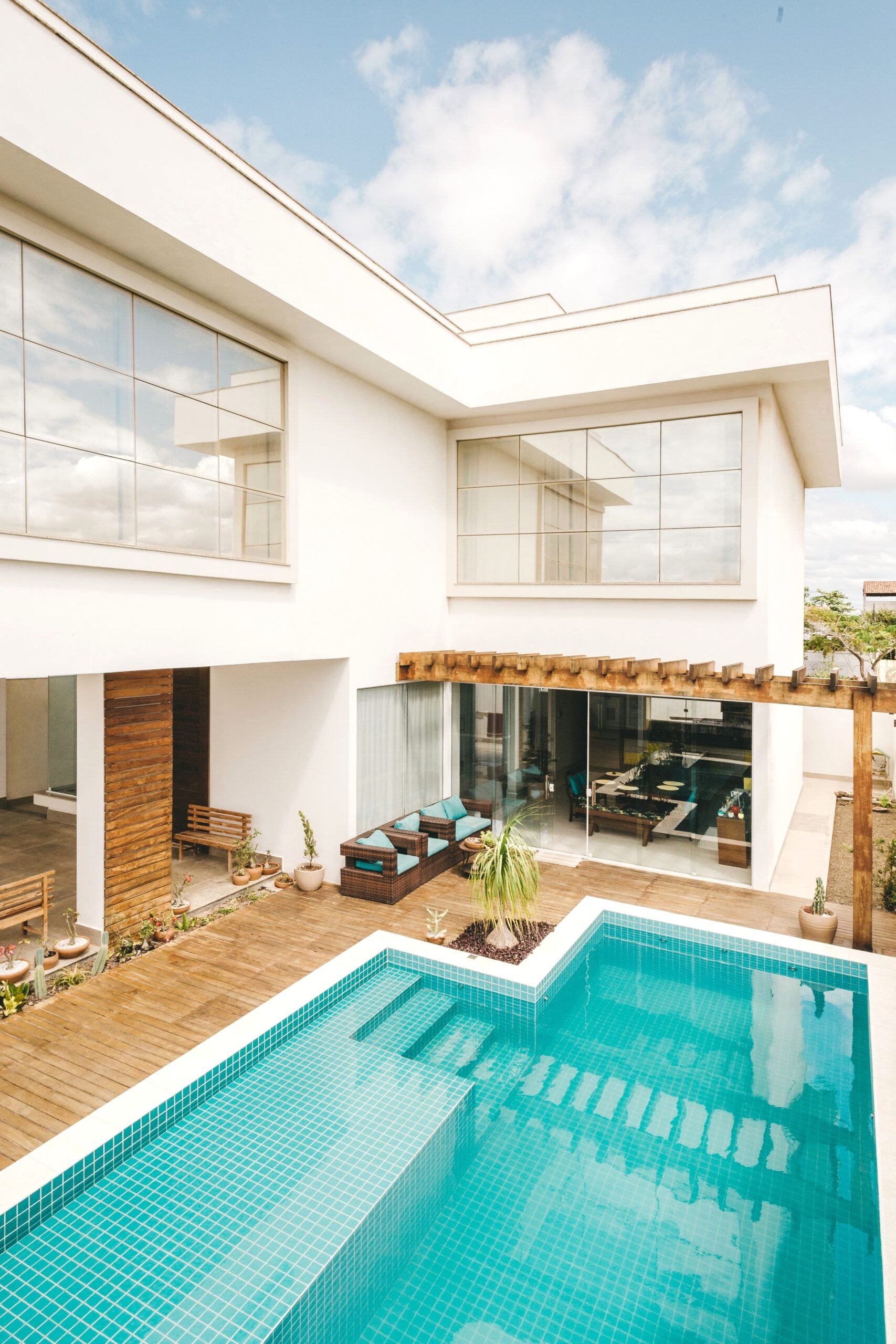Contemporary villa featuring a sleek pool and minimalist design under a bright sky. This article shares companies that help create a complete backyard pool ecosystem.