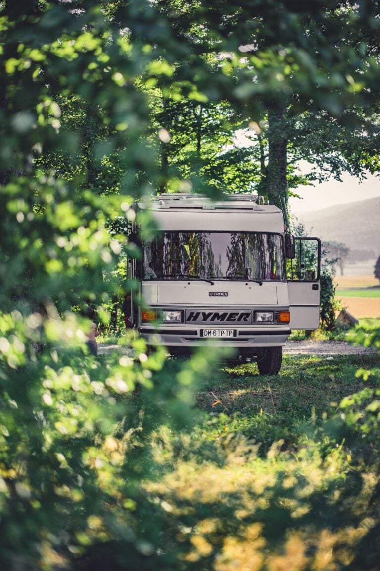 A tranquil scene of an RV nestled among lush greenery in a rural landscape. This article shares how to plan a relaxing RV trip through upstate South Carolina.