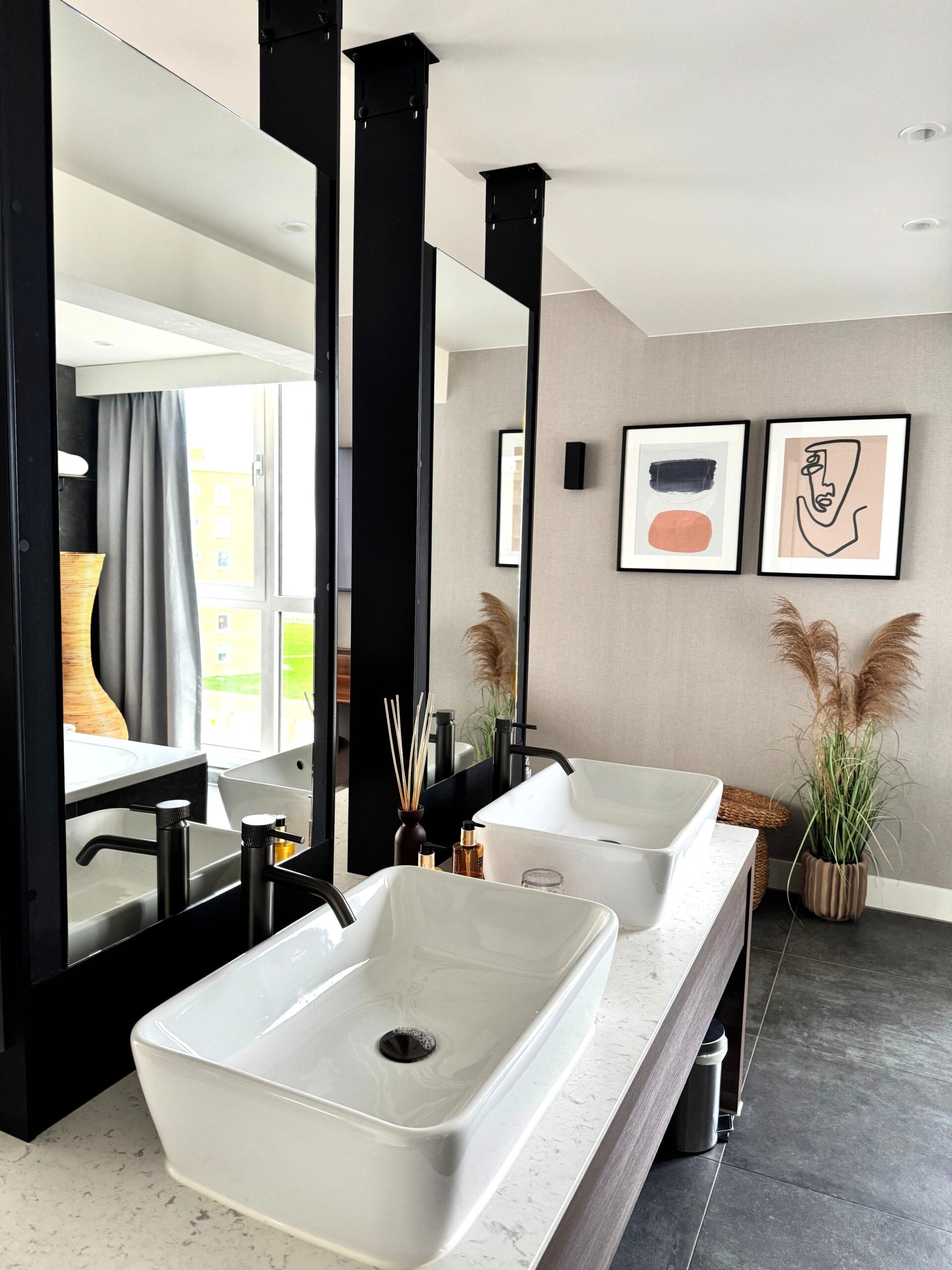 Elegant bathroom in The Hague with a modern, minimalist design featuring dual sinks and artistic decor. This article helps you in creating a bathroom that feels as good as it looks.