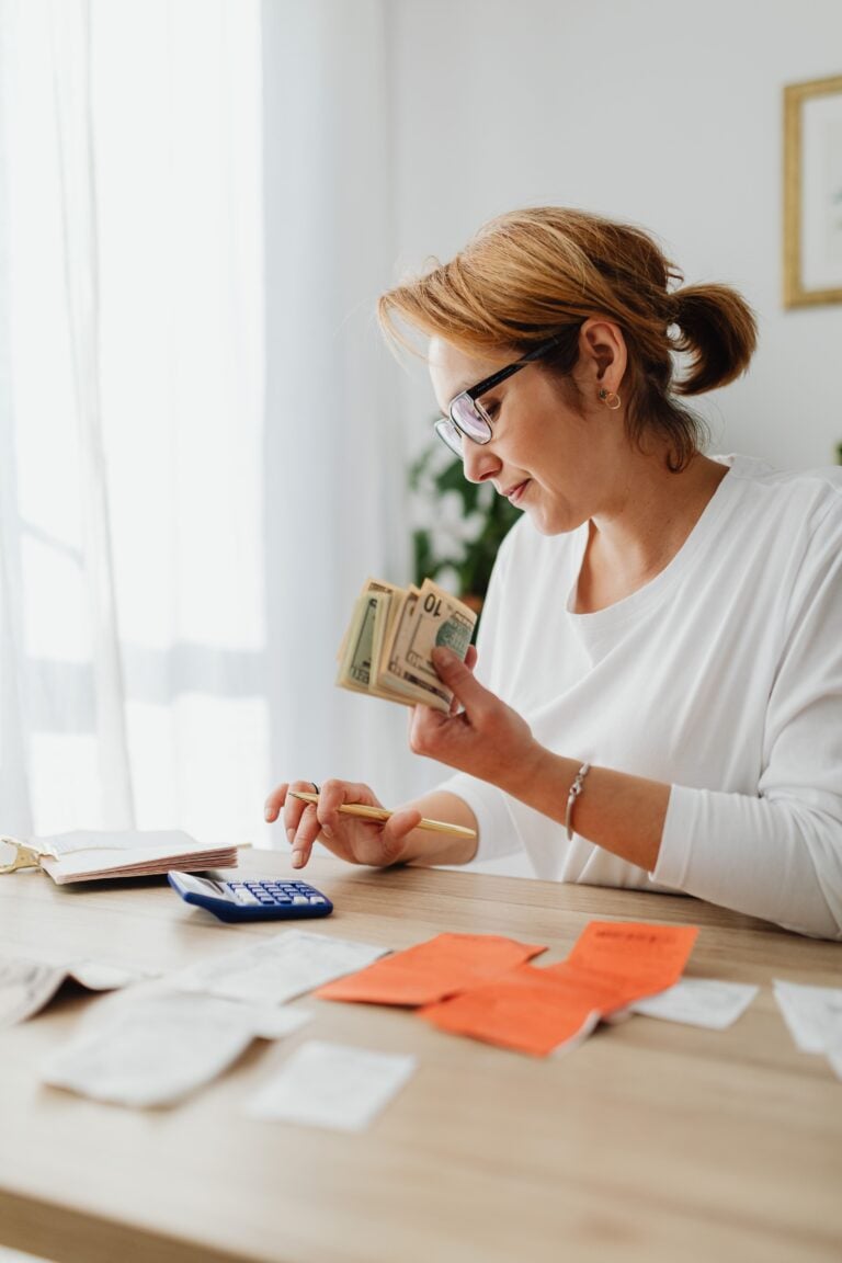 Woman counting cash and planning budget at indoor home office setting. This article shares how to build a personal cash flow.