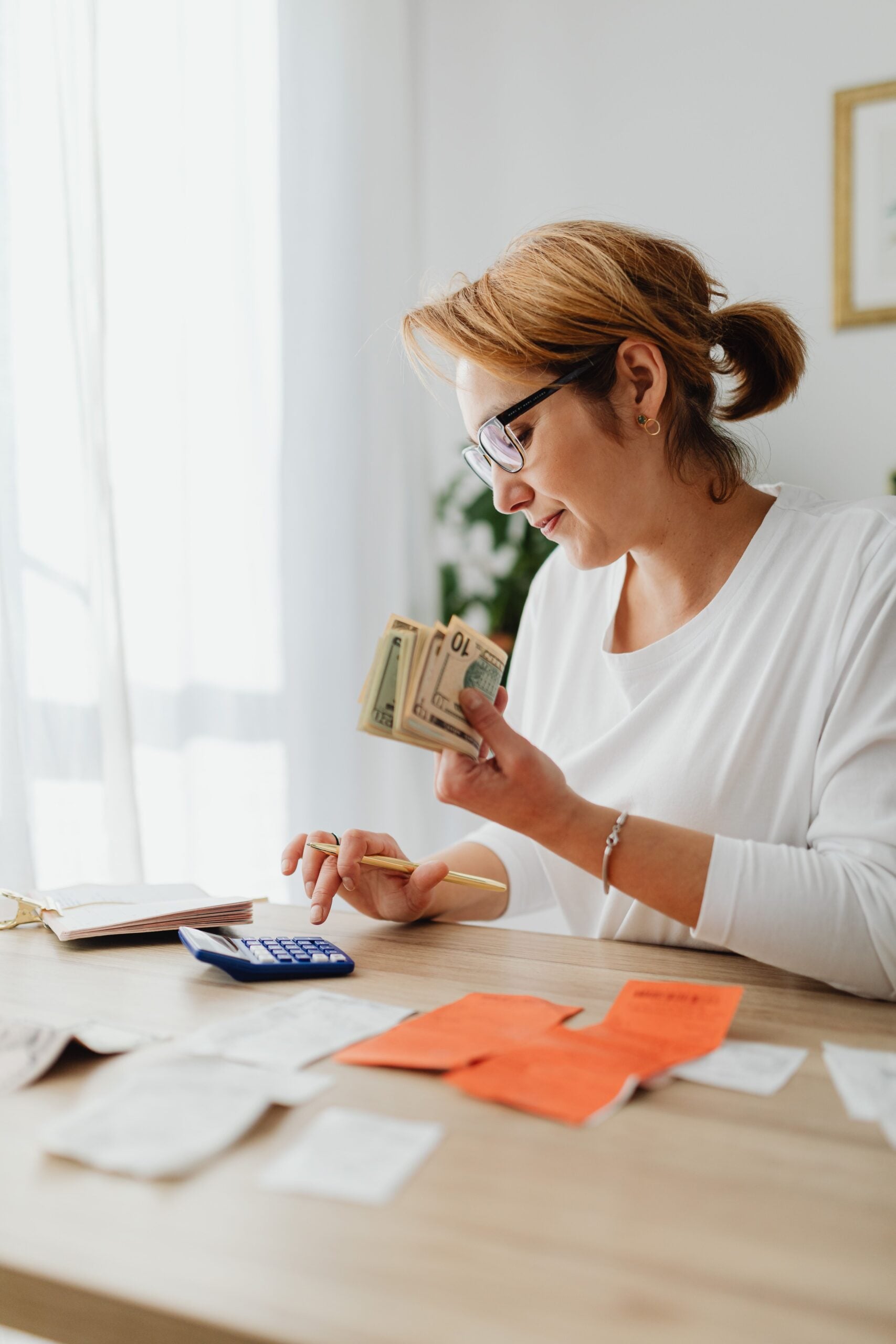 Woman counting cash and planning budget at indoor home office setting. This article shares how to build a personal cash-flow.