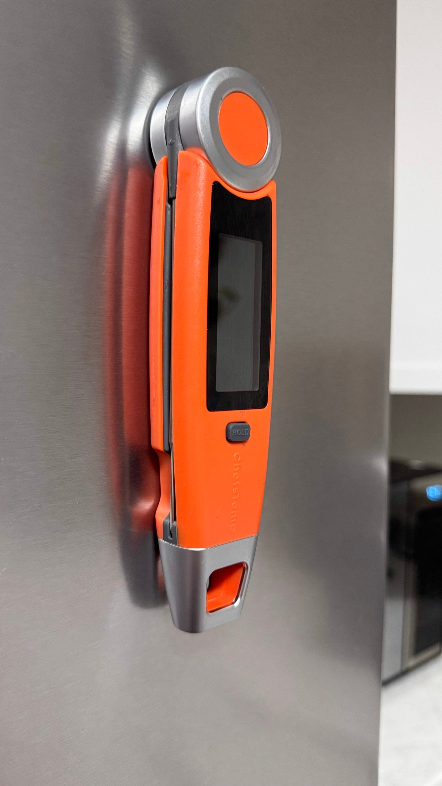 The ChefsTemp instant-read thermometer placed on a stainless steel fridge for easy use.