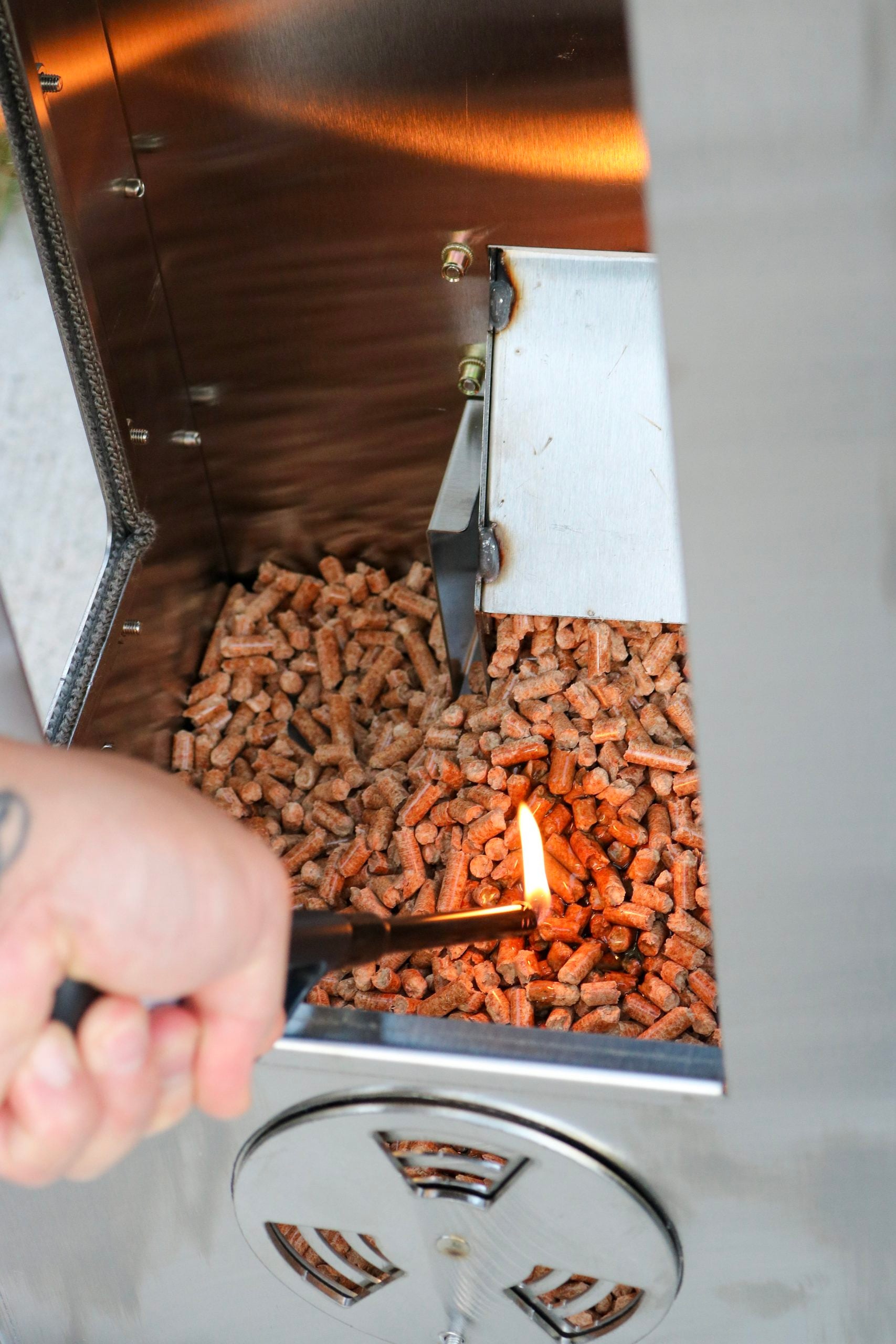 A hand places a flame over lighting gel fluid and is being lit for the first time.