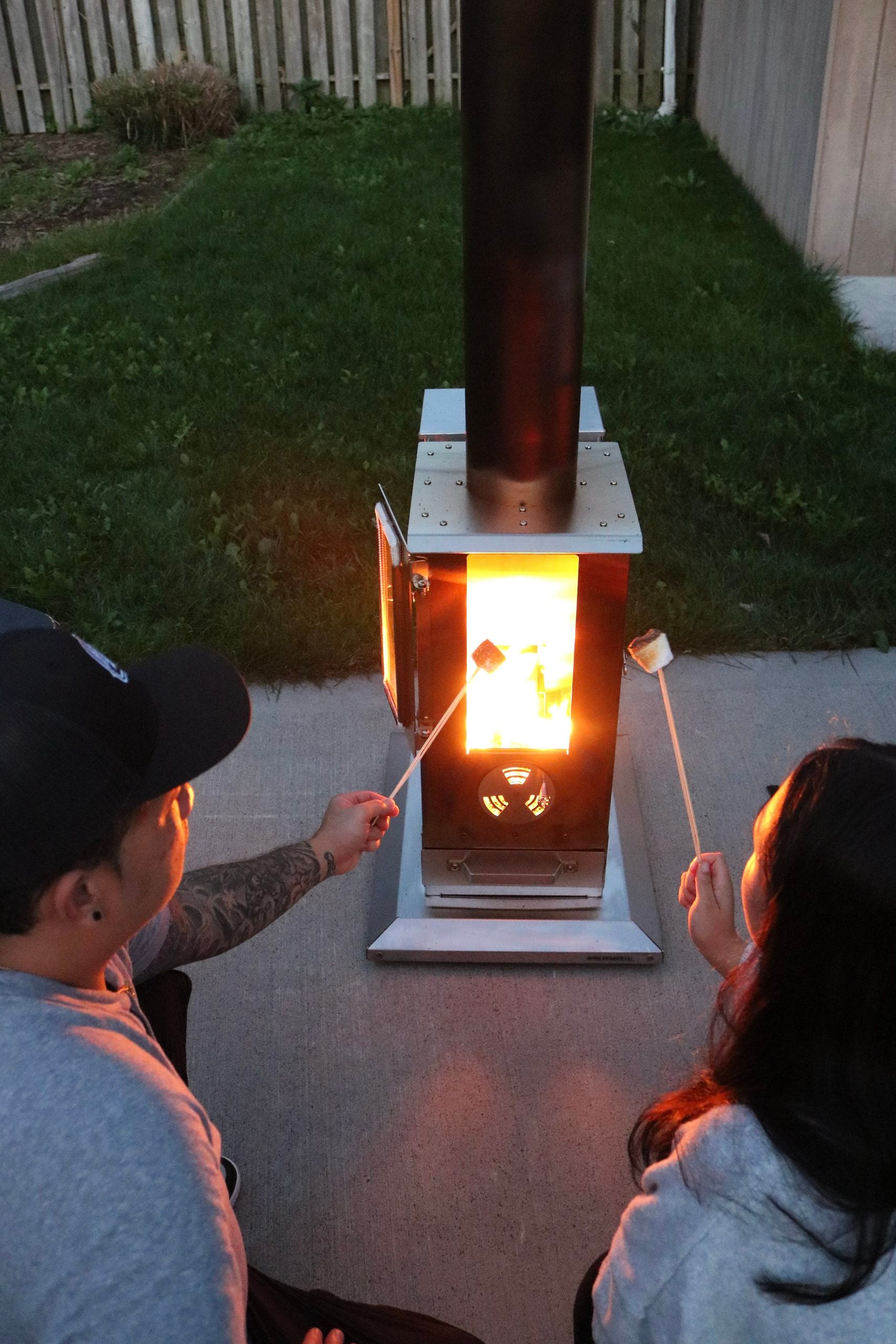 Darasak and Mimi roasting marshmallows on Timber Stove, Big Timber.